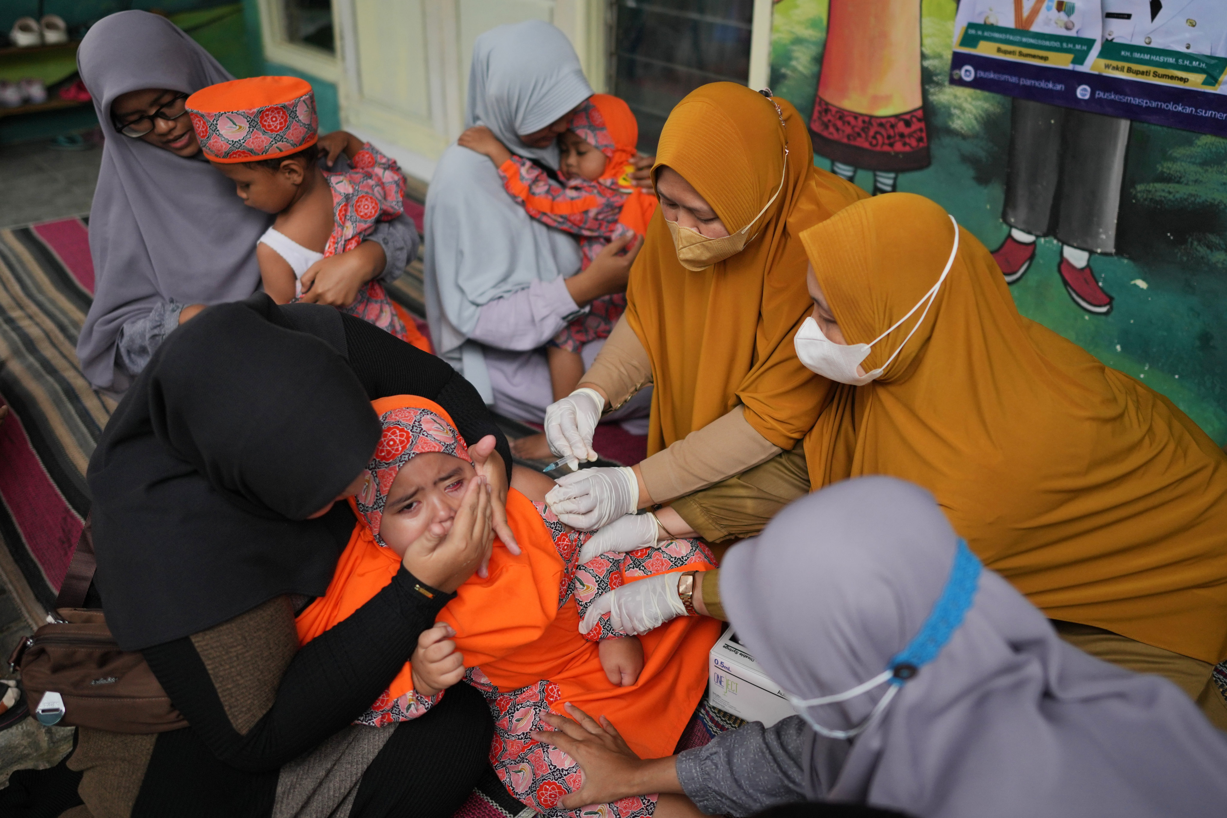 Health workers administer a measles vaccine to a child  following an outbreak in Sumenep, Indonesia, on Spetember 8. Photo: AP