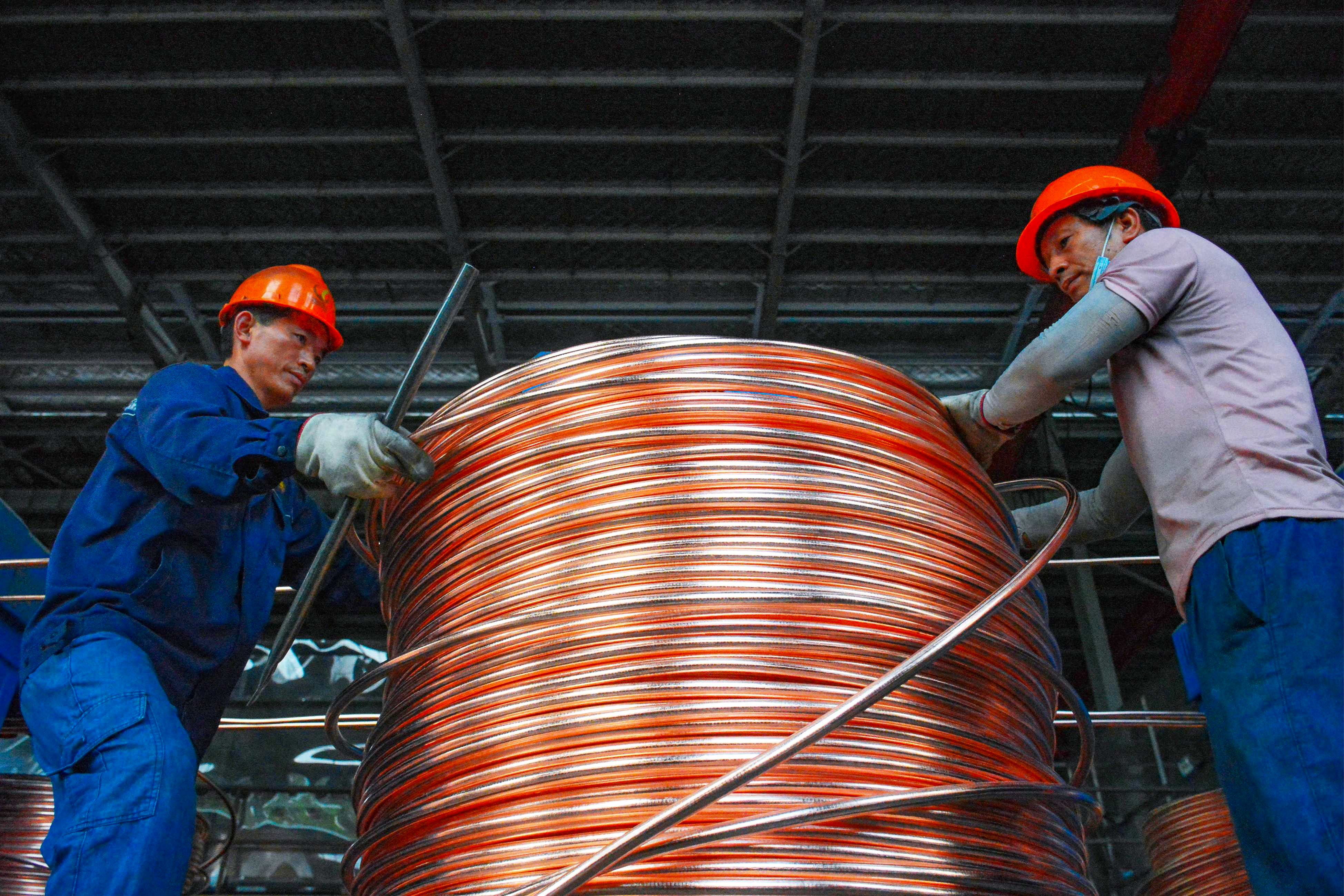 Employees wind copper rods at a workshop which recycles copper in Anqing, in Chinaís eastern Anhui province on July 11. Photo:  AFP