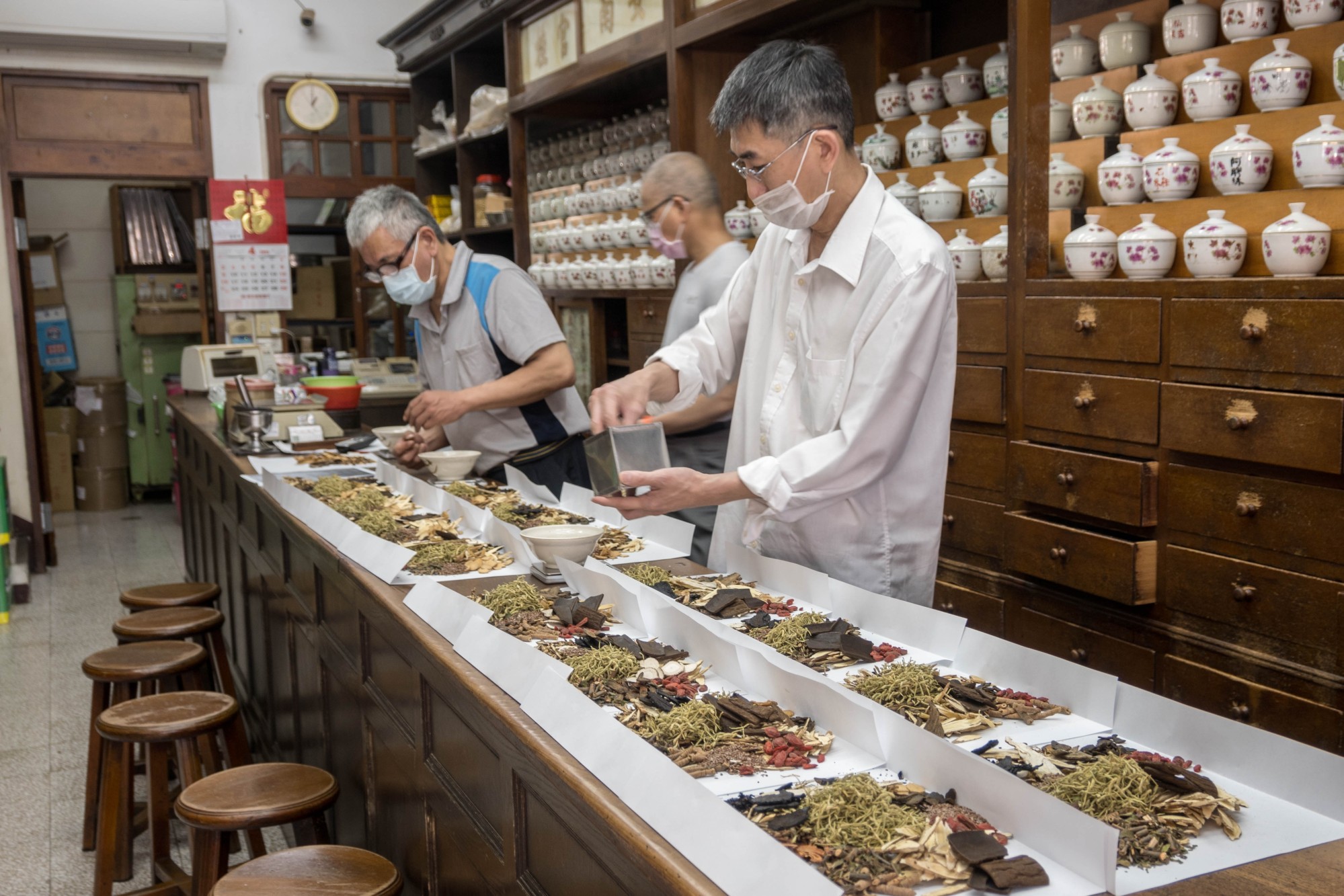Two men prepared a selection of natural raw herbal ingredients in a Chinese medicine house as part of a herbal tonic formula traditionally used in Traditional Chinese Medicine (TCM) for treating colds and flu. Photo: Shutterstock Two men prepared a selection of natural raw herbal ingredients in a Chinese medicine house as part of a herbal tonic formula traditionally used in Traditional Chinese Medicine (TCM) for treating colds and flu. Photo: Shutterstock