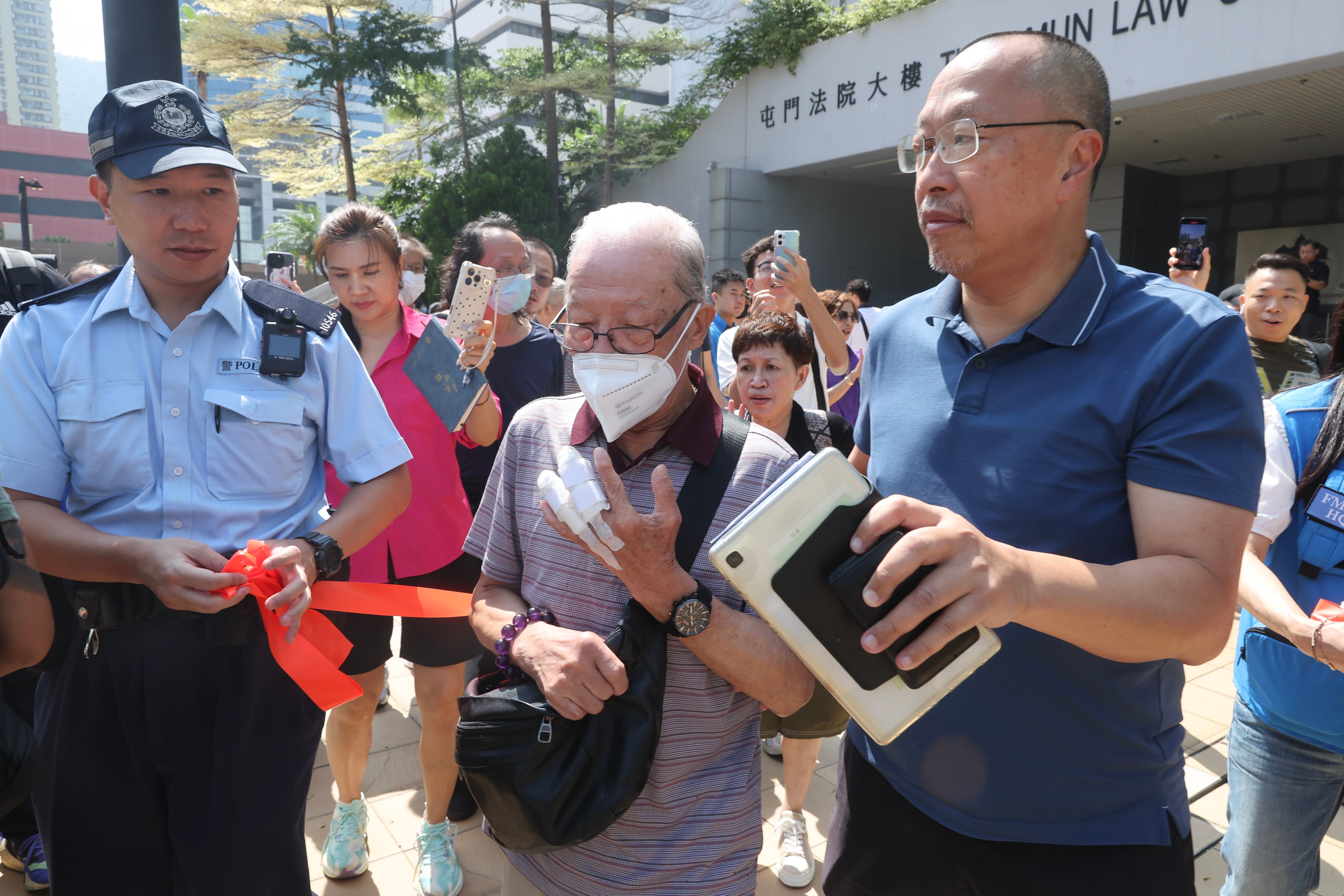 Ho Huen (centre) leaves Tuen Mun Court after an earlier appearance. Photo: Edmond So