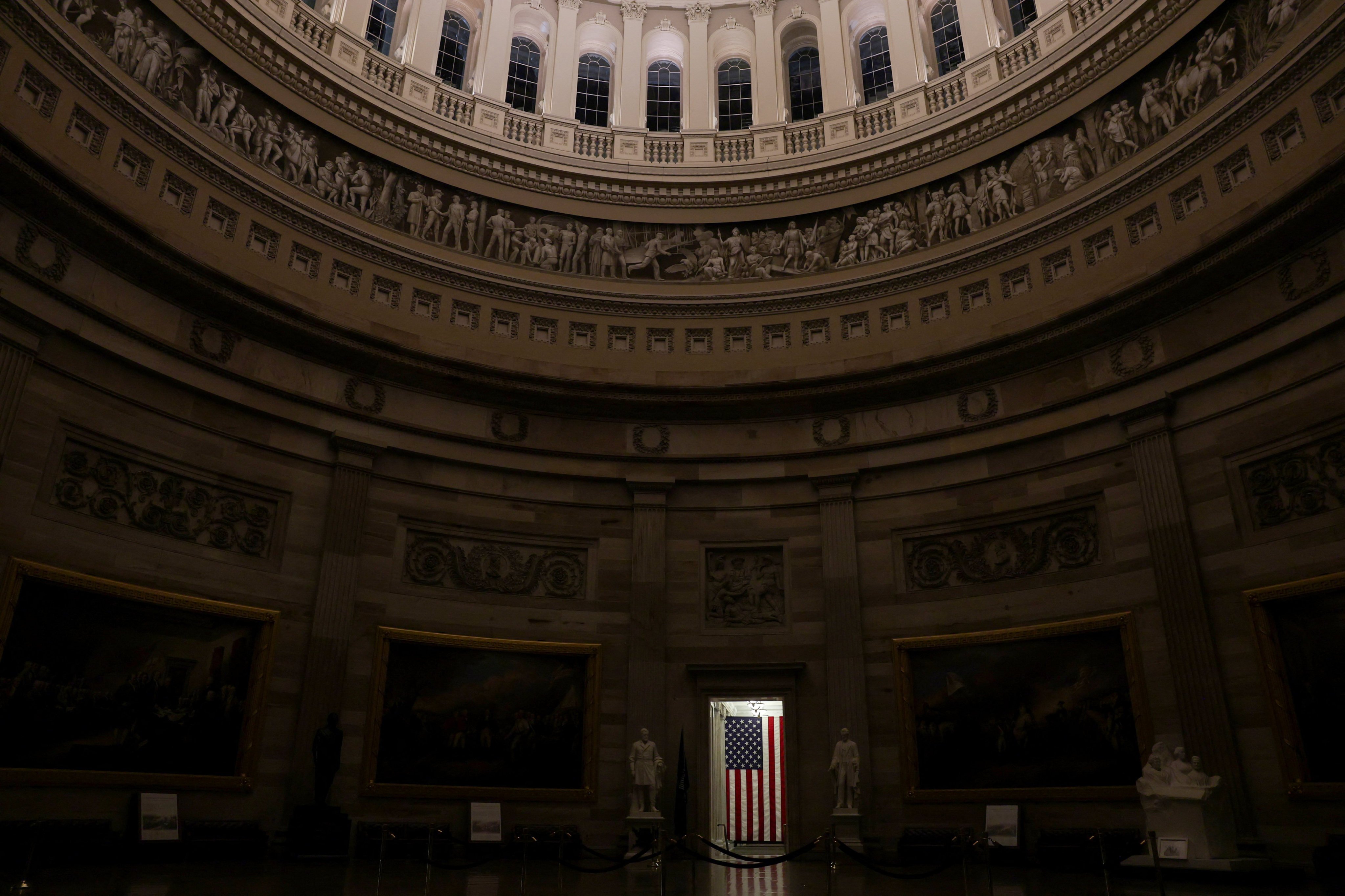 A US flag illuminated in a doorway of the otherwise empty rotunda at the US Capitol in the hours before a partial government shutdown in Washington DC. Photo: Reuters