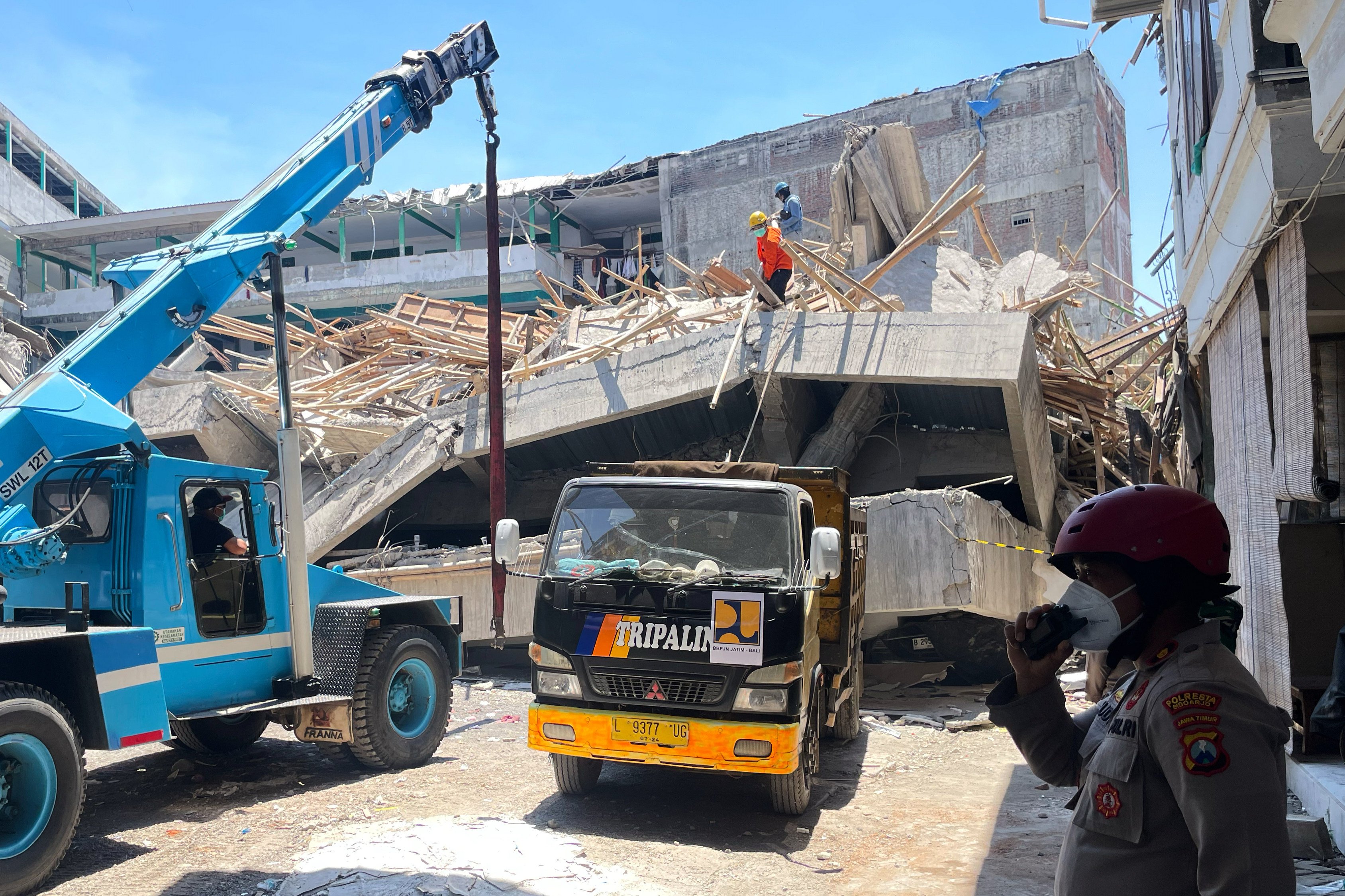 A crane is brought in to clear the rubble at the site where a building under construction at an Islamic boarding school. Photo: AP