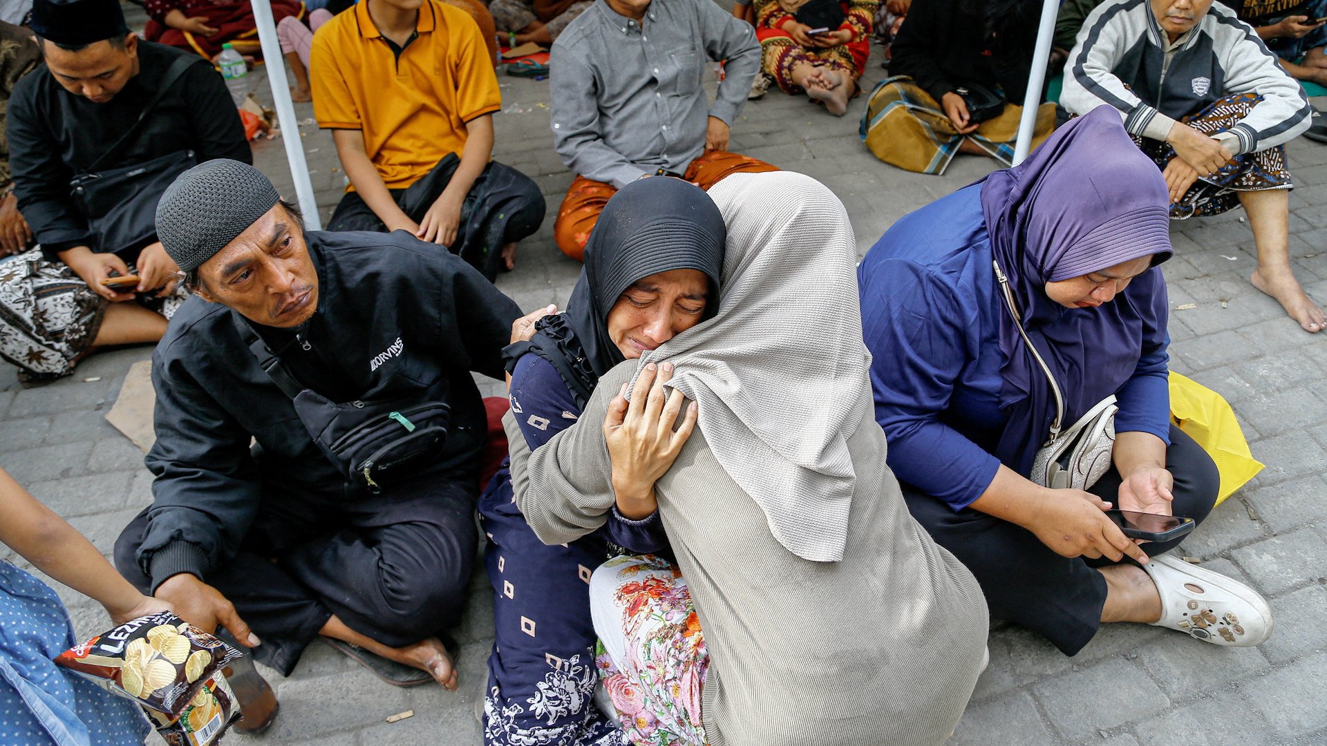A relative of a victim of a collapsed building reacts in Sidoarjo
