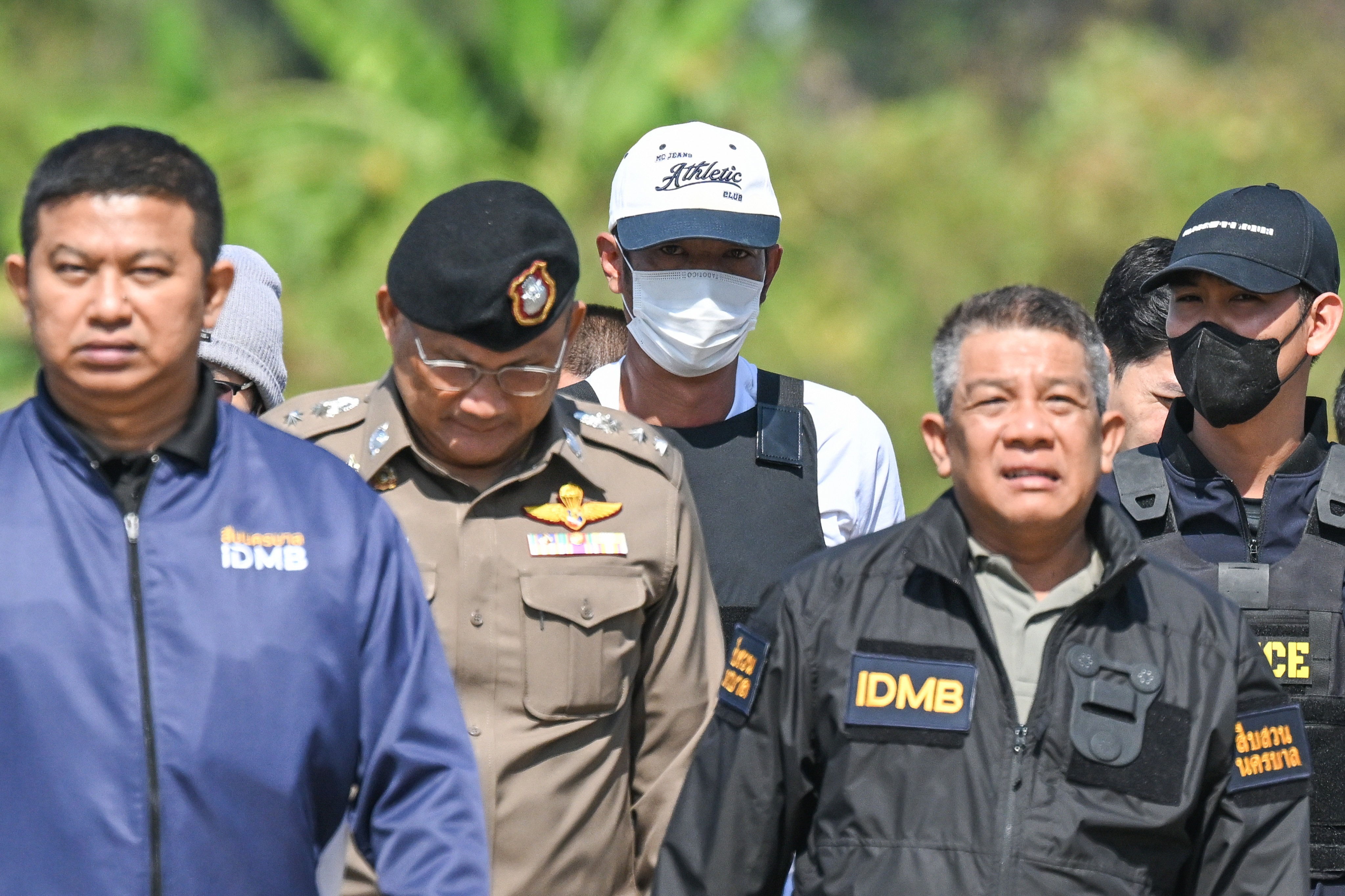 Thai police officers escort Ekkalak Pheanoi (centre), accused of killing of Cambodian politician Lim Kimya, after he is deported from Cambodia on January 11. Photo: AP