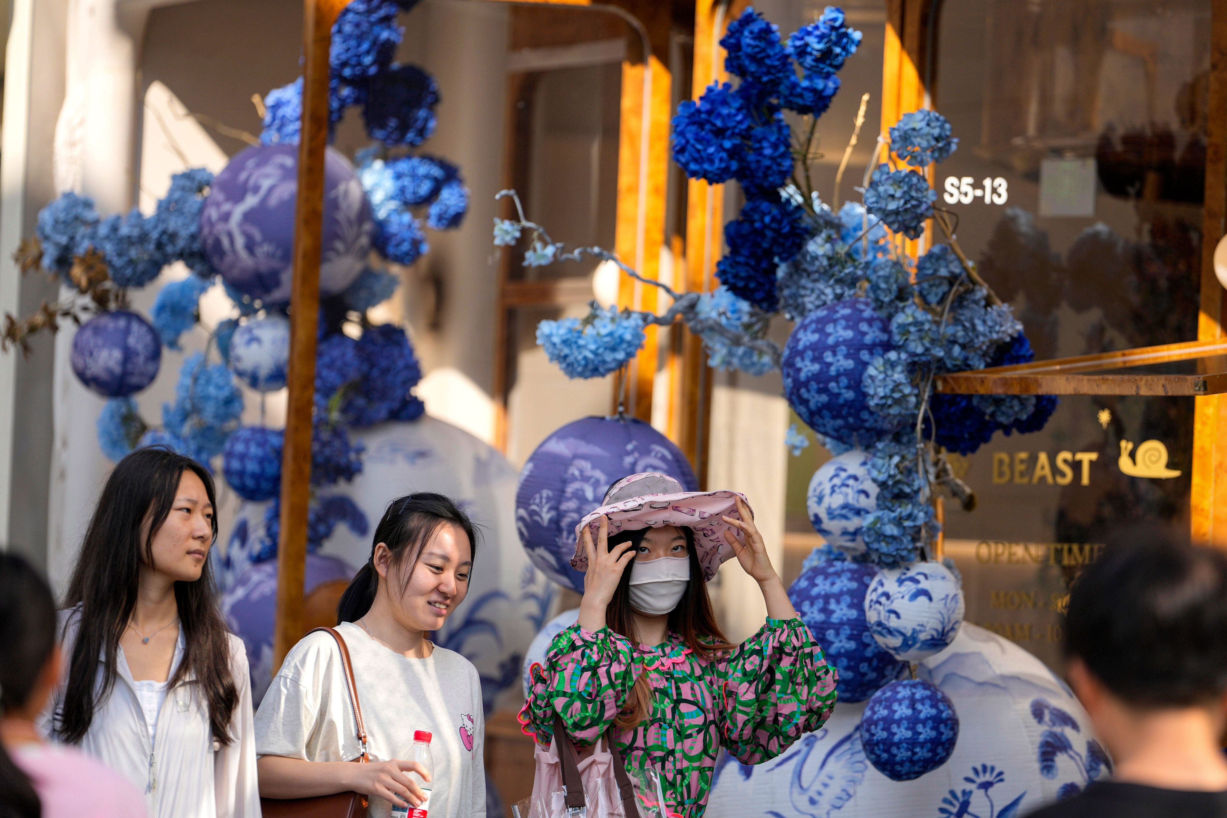 People pass a flower shop in a trendy shopping district in Beijing on October 2, 2025. Photo: AP Photo