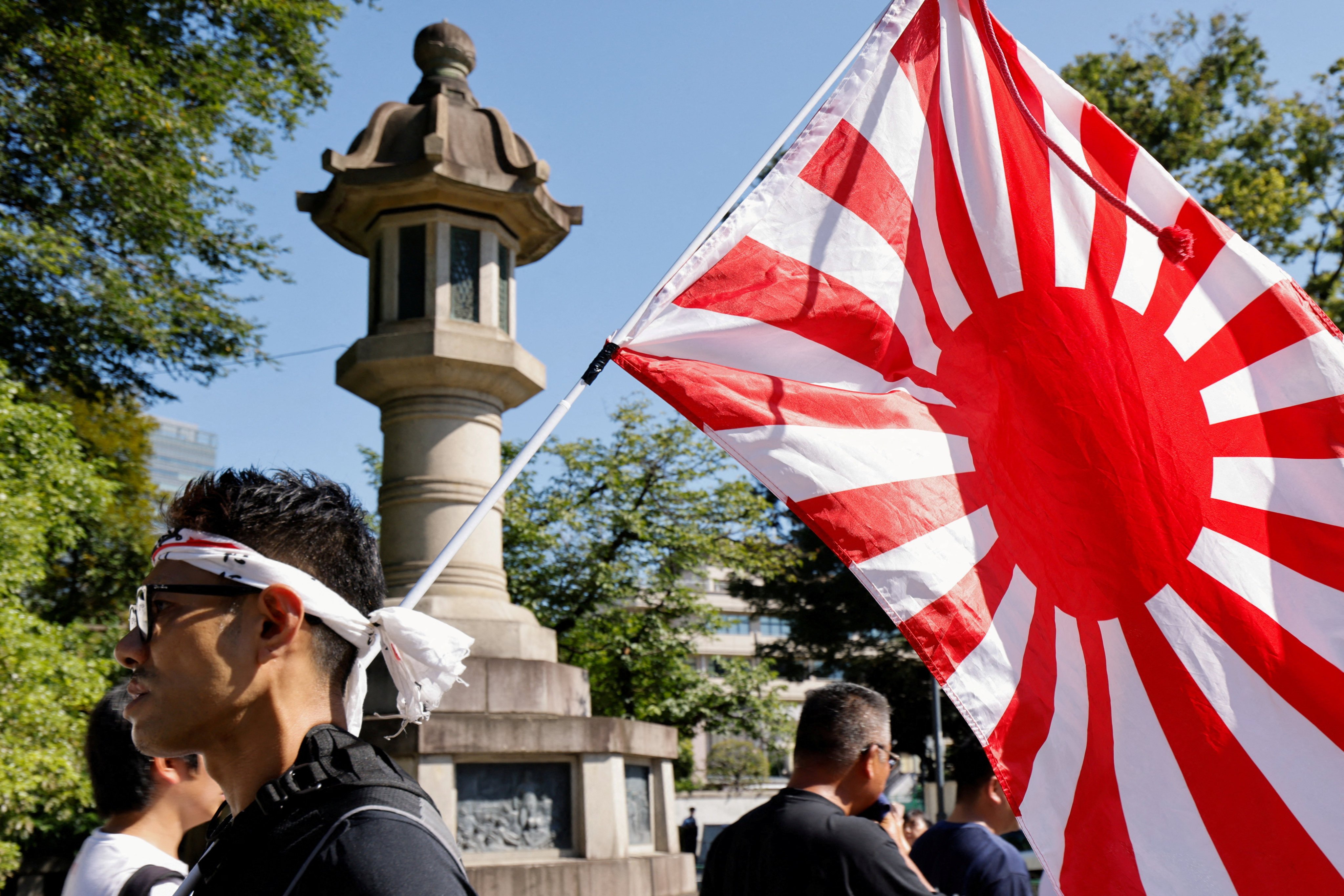 A person displays a Rising Sun flag at the Yasukuni shrine in Tokyo on the 80th anniversary of Japan’s surrender in WWII  on August 15. Photo: Reuters