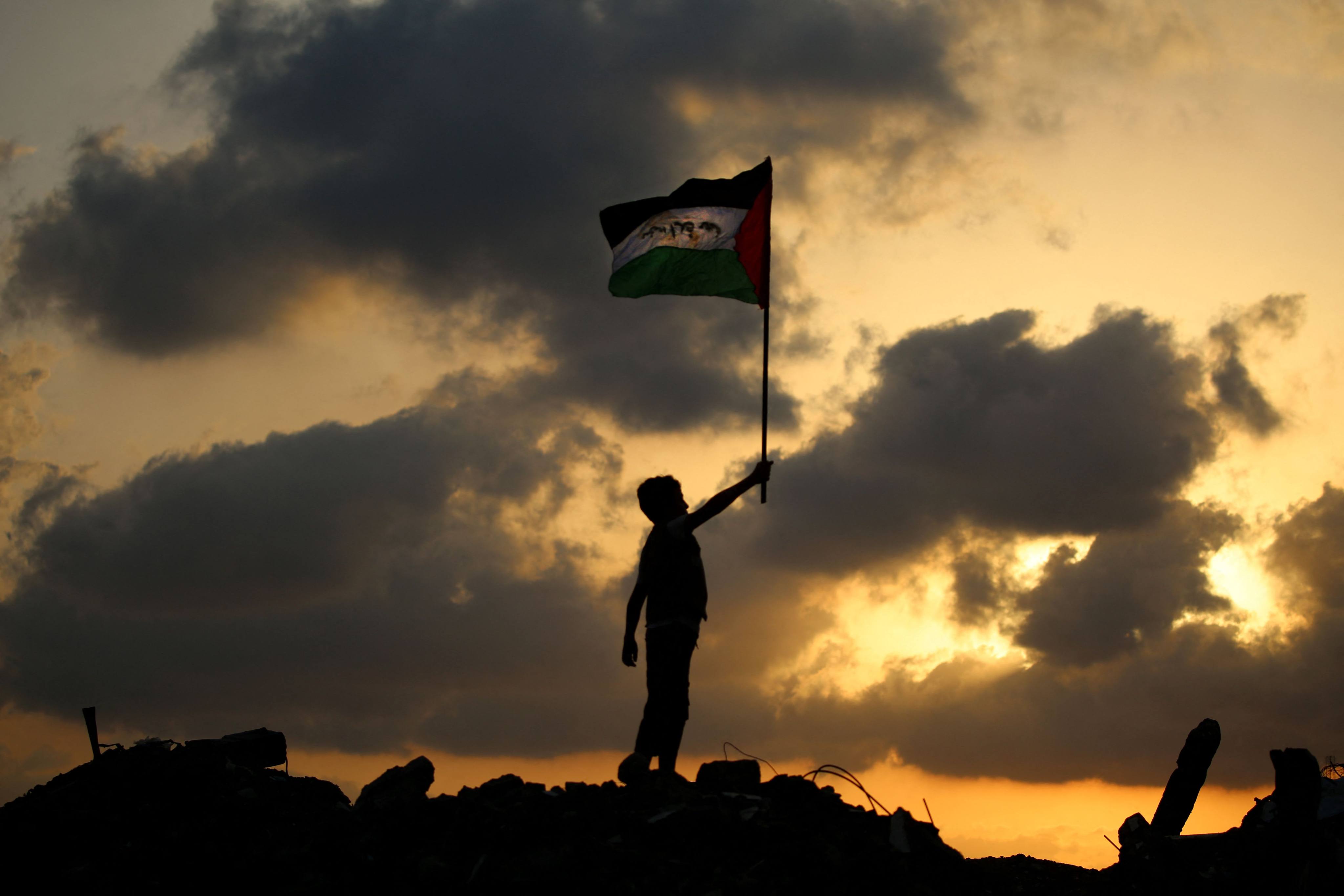 A displaced Palestinian child waves the Palestinian national flag at the Bureij camp for refugees in the central Gaza Strip on September 22. Photo: AFP