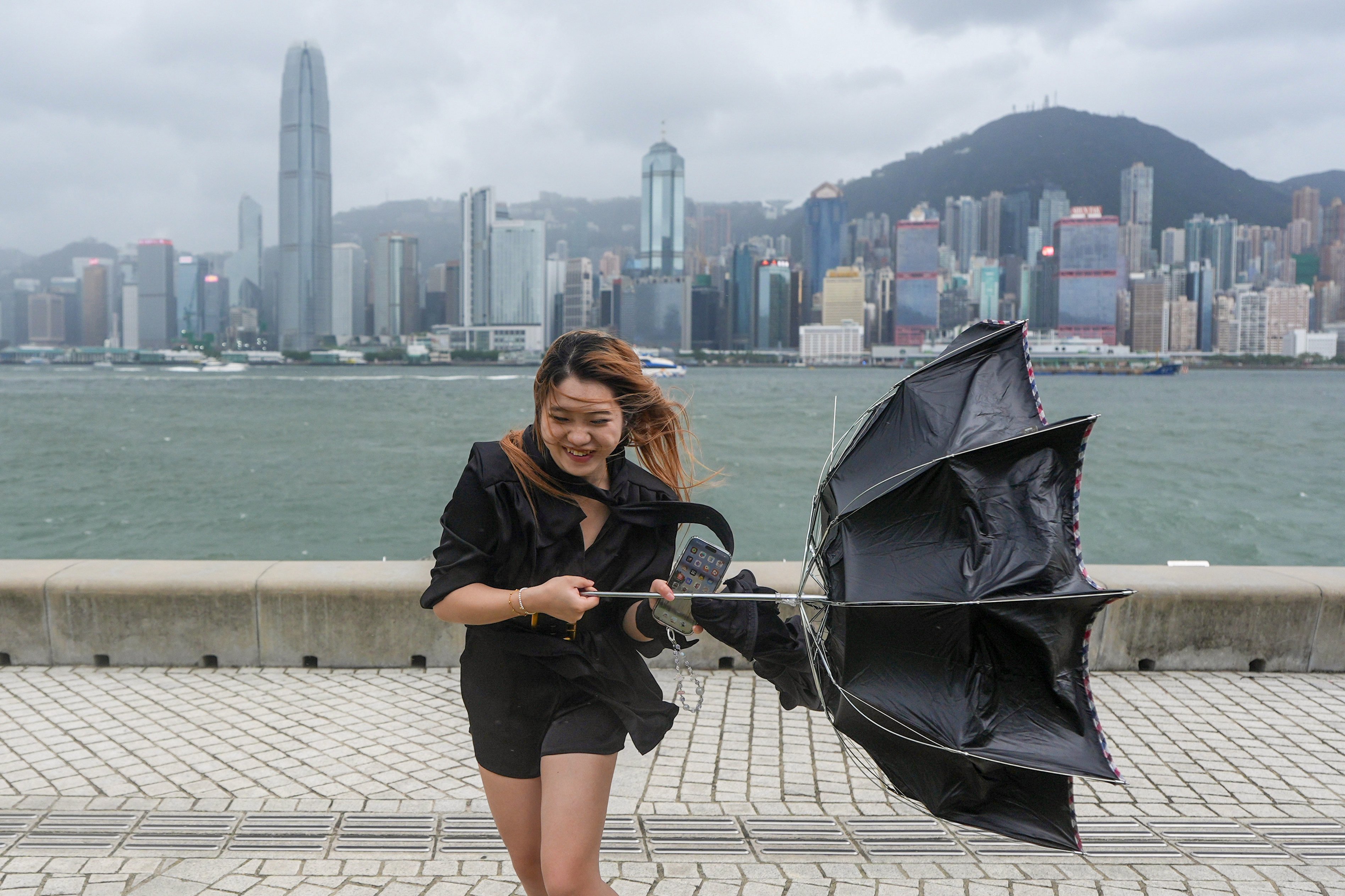 A woman contends with strong winds at the West Kowloon Cultural District on Saturday afternoon. Photo: Eugene Lee