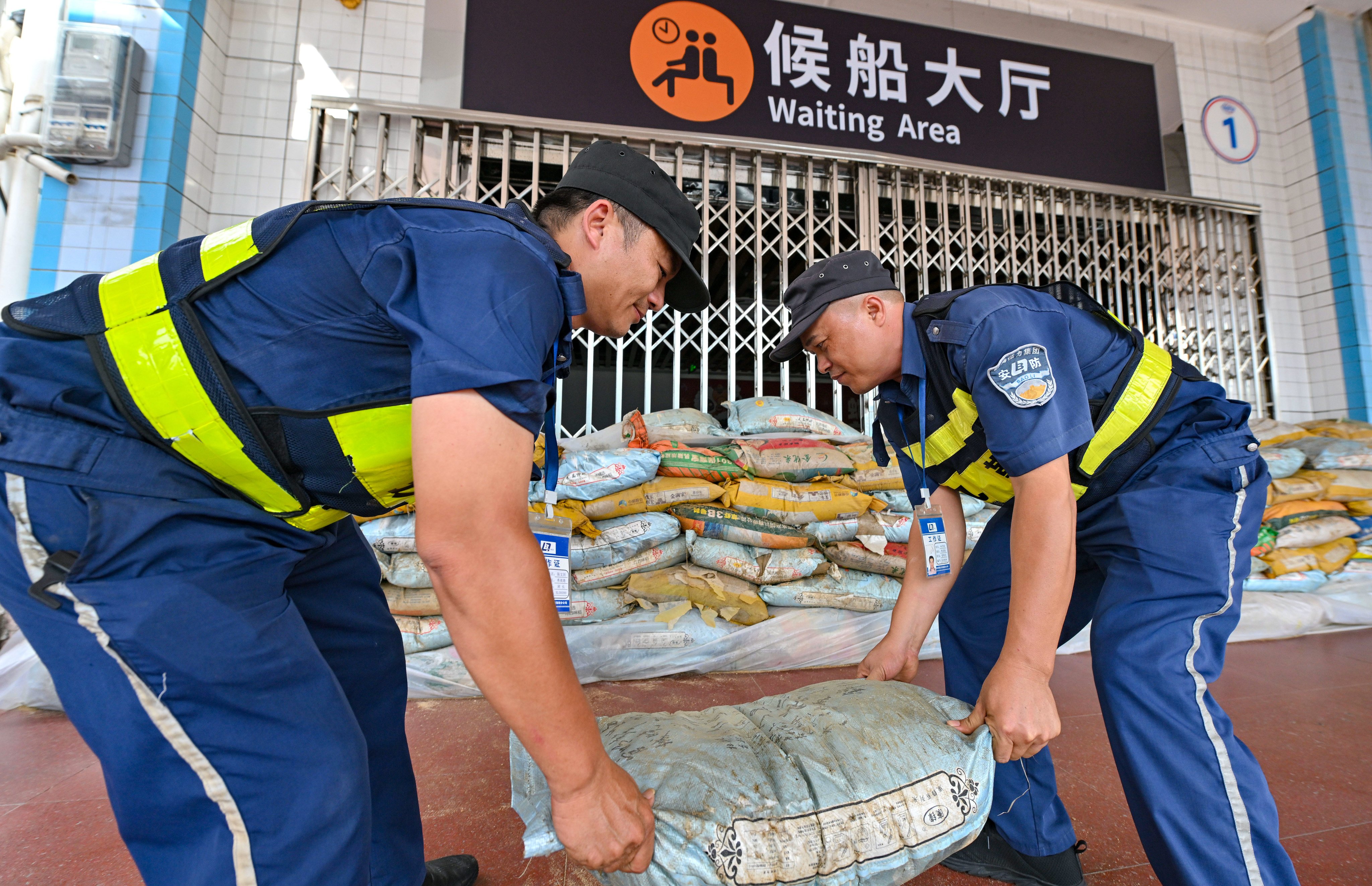 Port staff lay sandbags outside a waiting area in Haikou, capital of Hainan province, on Sunday. Photo: Xinhua