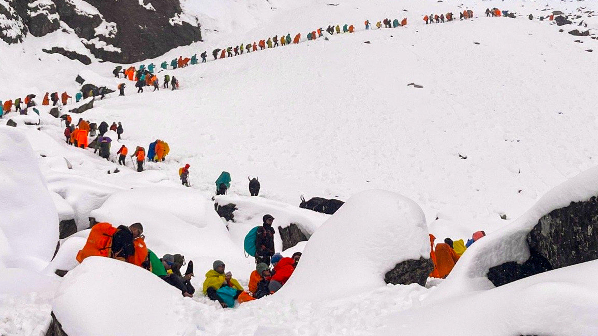 Rescuers guide hikers through heavy snow down the eastern slopes of Mount Everest while hundreds remain stranded
