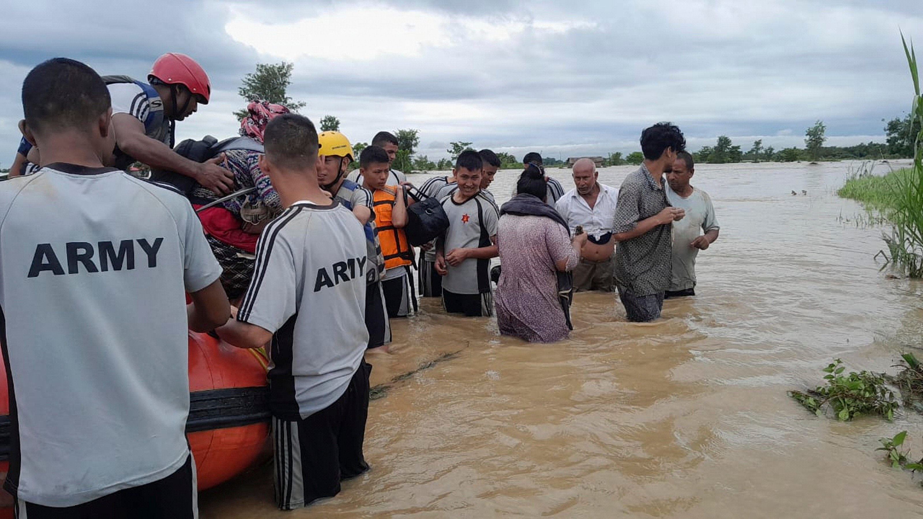 Nepalese army staff help survivors after a flood in Jhapa district in eastern Nepal on Sunday. Photo: Nepal Army/AP