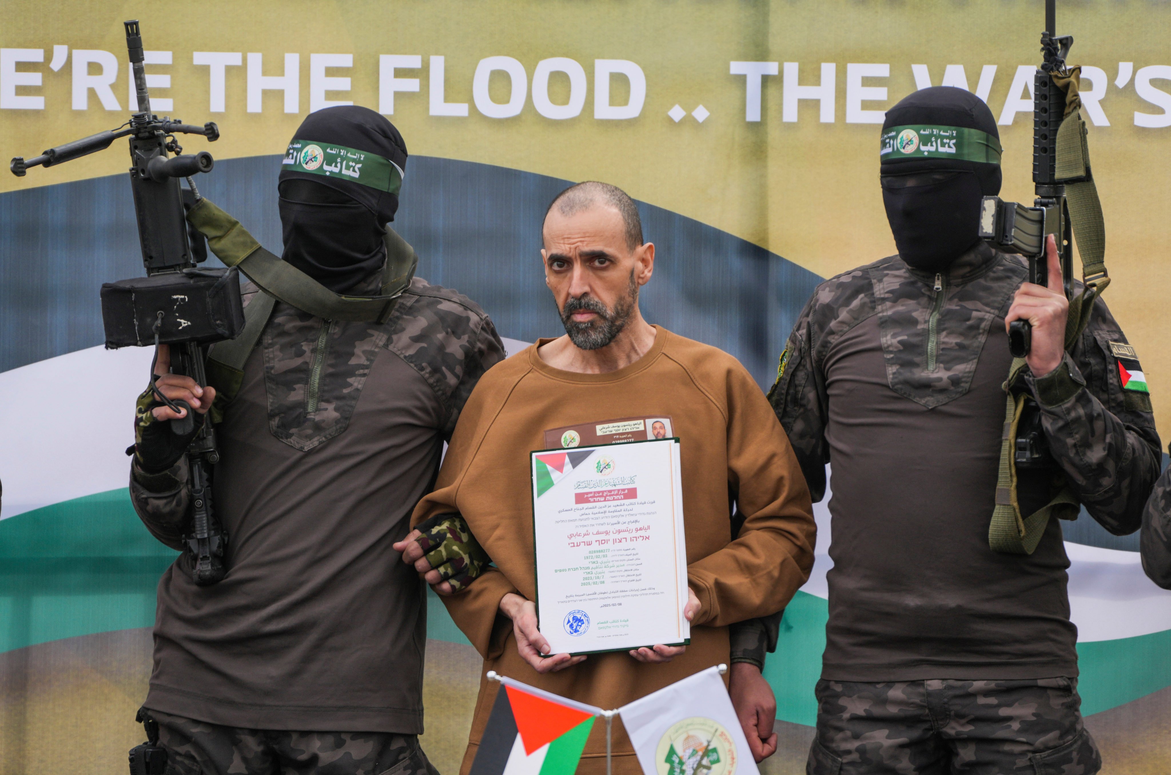 Eli Sharabi, stands on a stage with Hamas fighters before being handed over to the Red Cross for release in February. File photo: AP