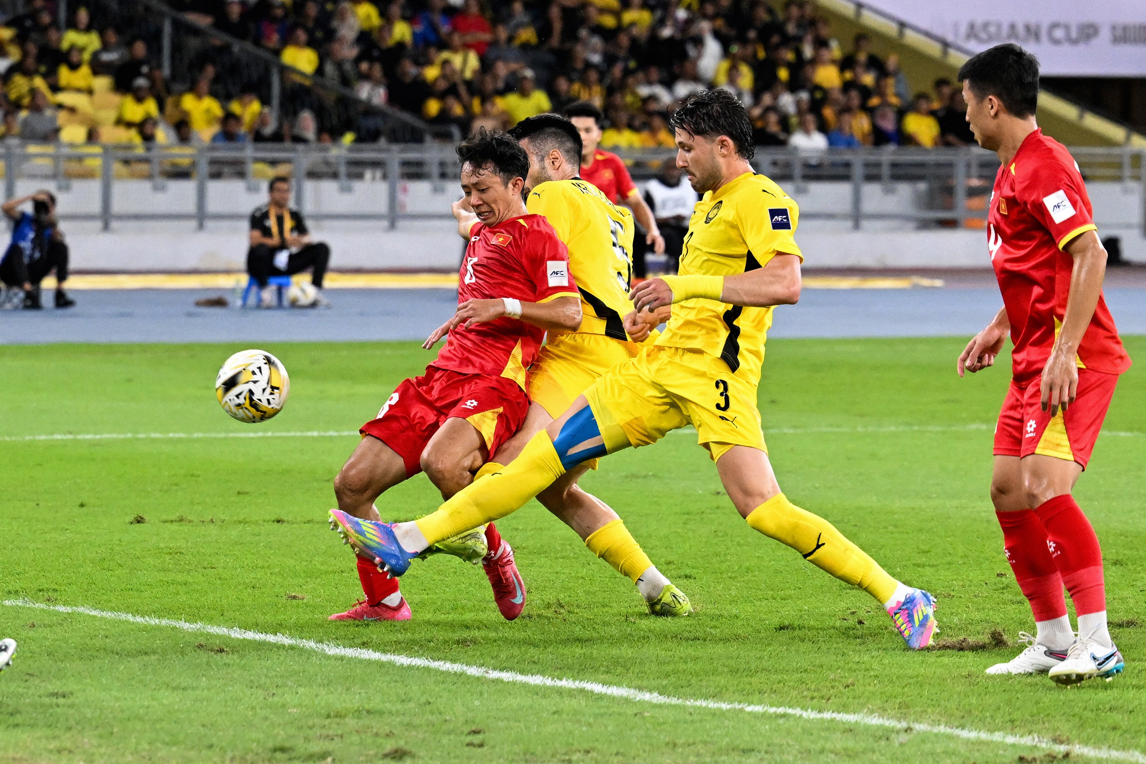 Vietnam’s Chau Ngoc Quang (left) fights for the ball with Malaysia’s players during the Asian Cup qualifier match between Malaysia and Vietnam in Kuala Lumpur on June 10. Photo: AFP