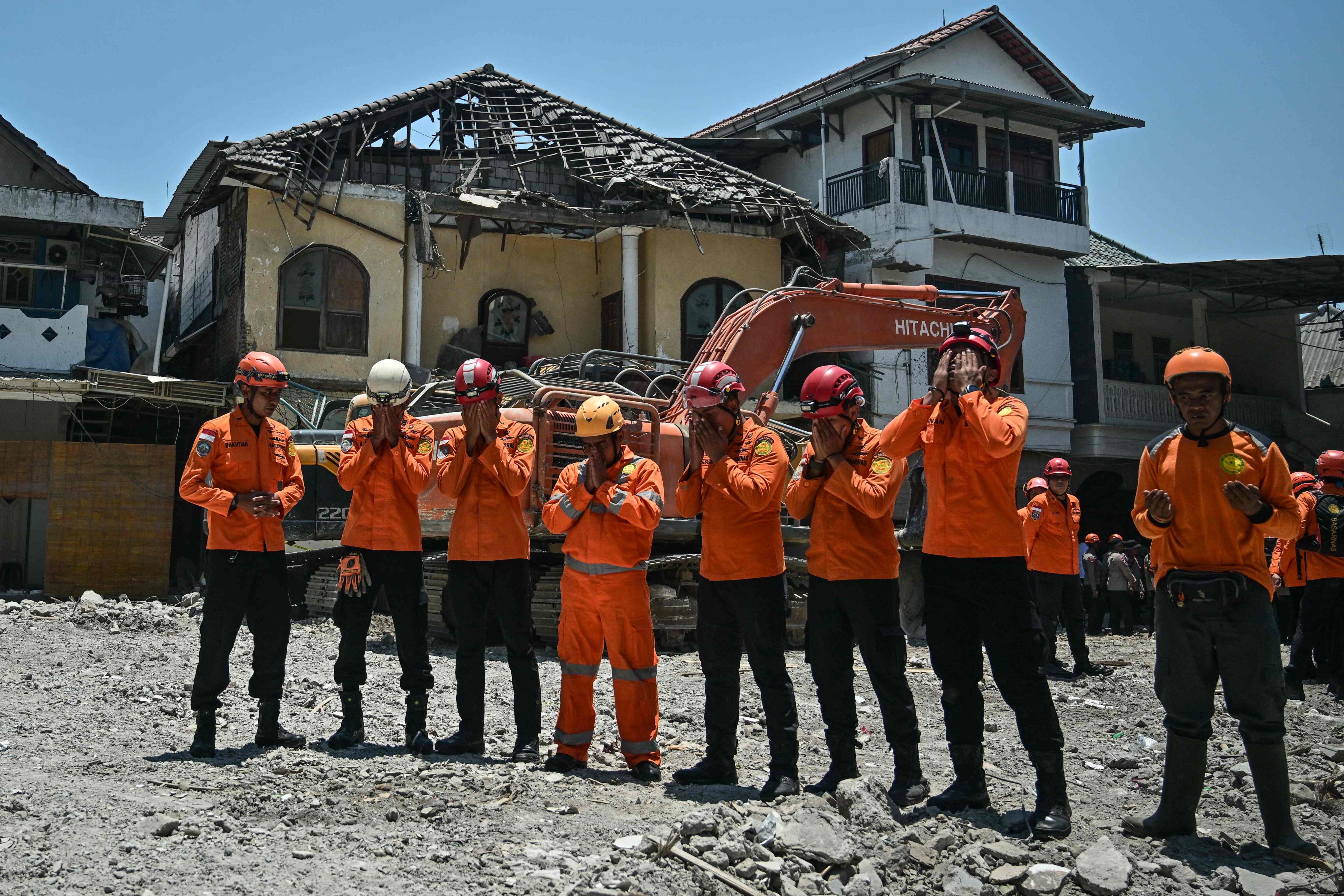 Rescuers pray after a closing ceremony marking the end of debris removal and search operations at the site of the collapsed Al Khoziny Islamic Boarding School in Sidoarjo on Tuesday. Photo: AFP