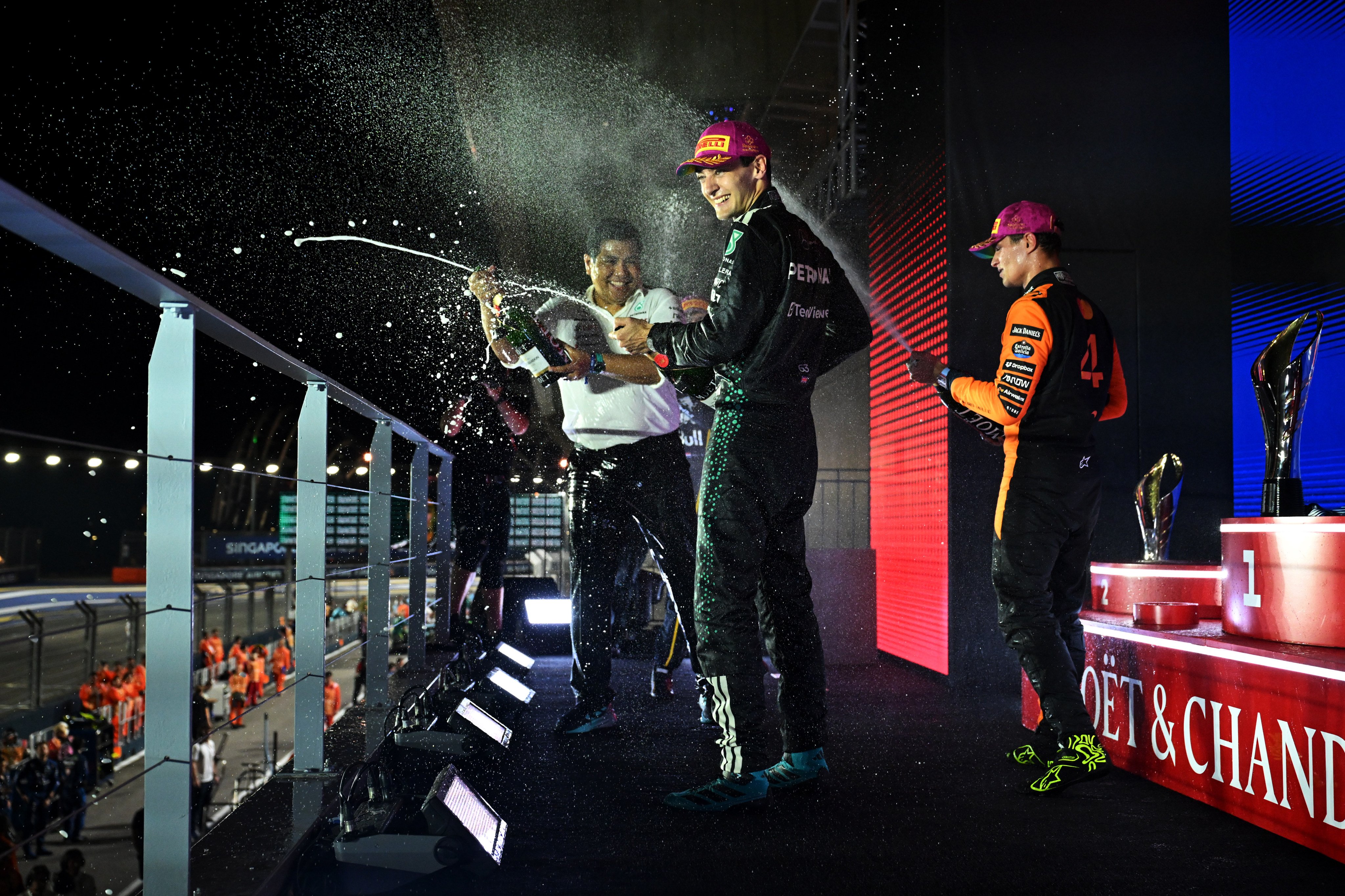 Race winner George Russell (centre) of Mercedes-AMG Petronas Formula One Team, Petronas CEO Tengku Muhammad Taufik Tengku Aziz (left) and third-placed Lando Norris of McLaren celebrate on the podium with champagne during the Singapore Grand Prix on Sunday. Photo: Formula 1 via Getty Images