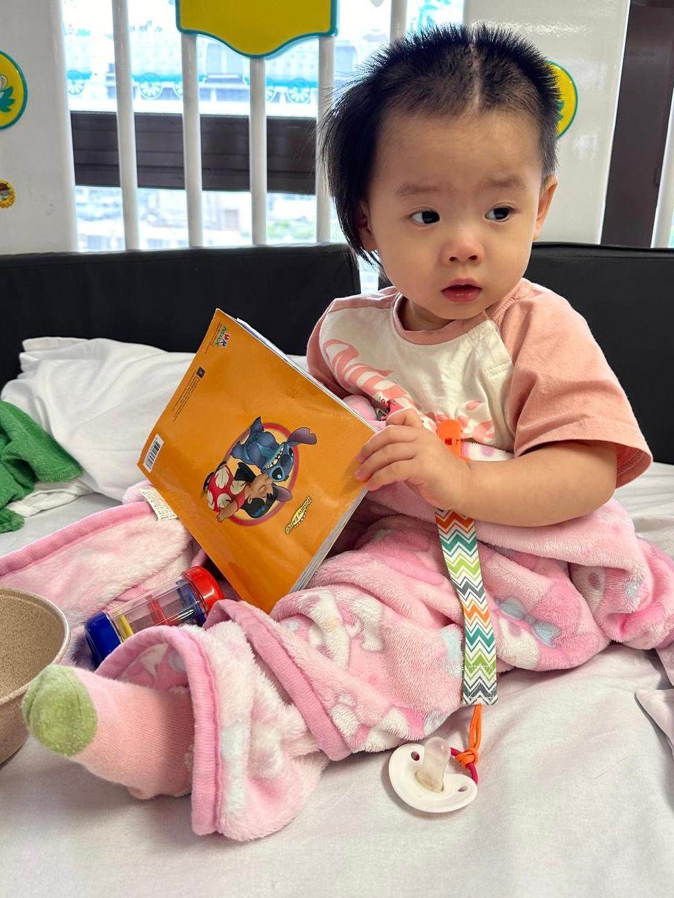Suet-yee, who previously could not raise her right hand, can now move her fingers slightly and hold a dummy, her mum says. Photo: Family of Little Suet-yee
