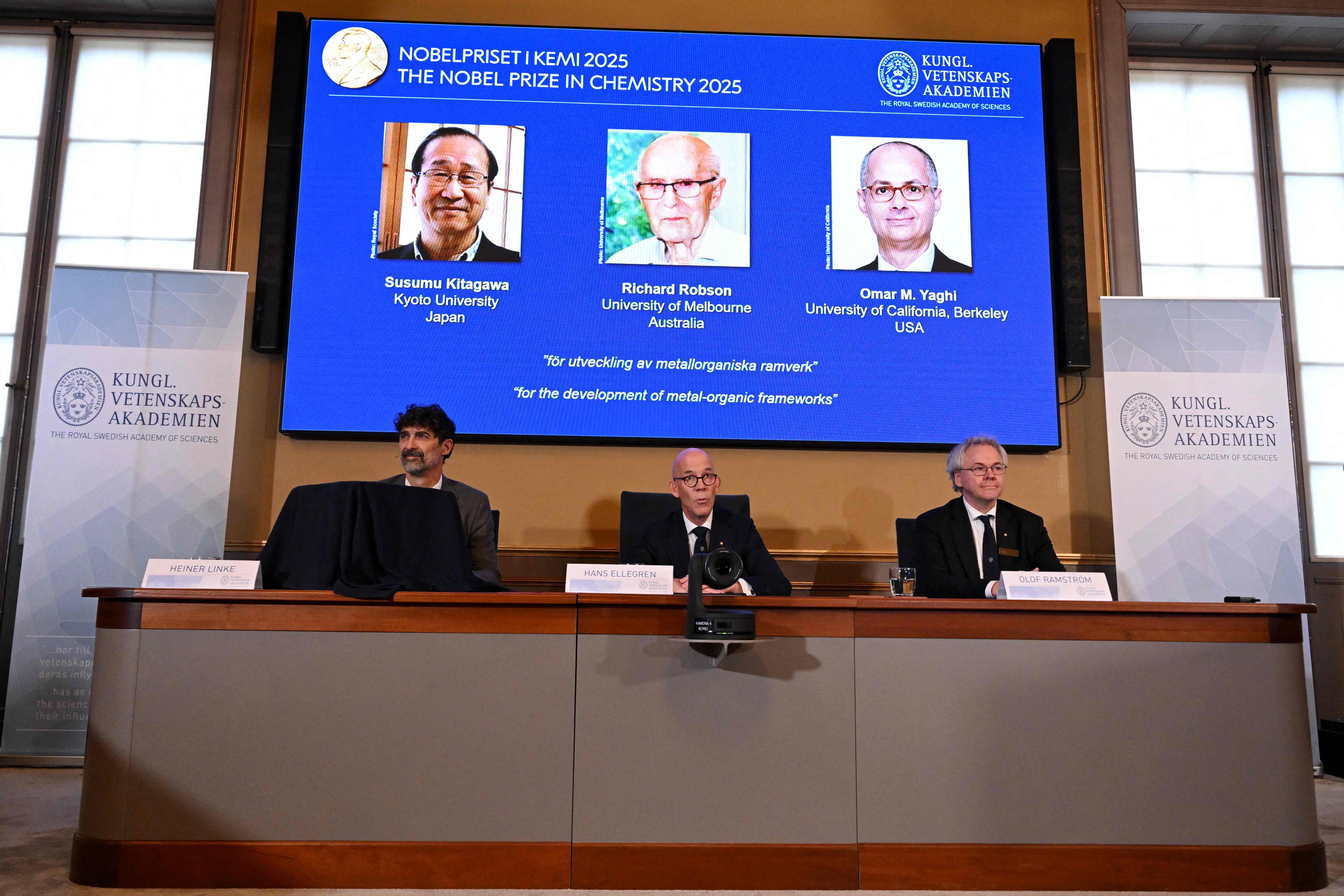 A screen shows Japan’s Susumu Kitagawa, UK-born Richard Robson and American-Jordanian Omar M Yaghi as the winners of the Nobel Prize in Chemistry on Wednesday. Photo: AFP
