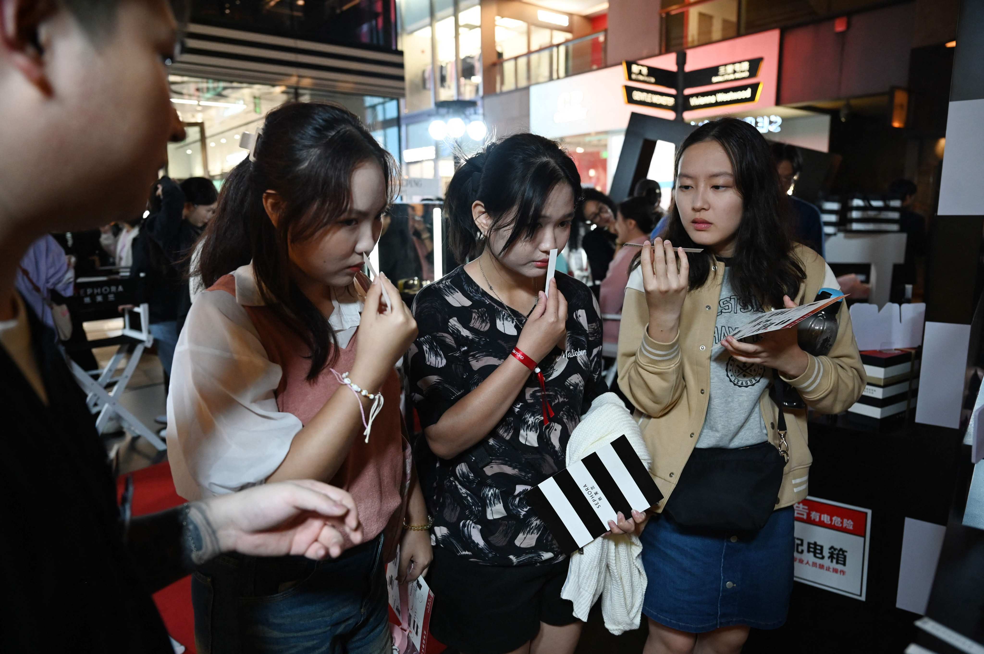 Women try perfume samples at a Beijing shopping mall on Tuesday. Photo: AFP