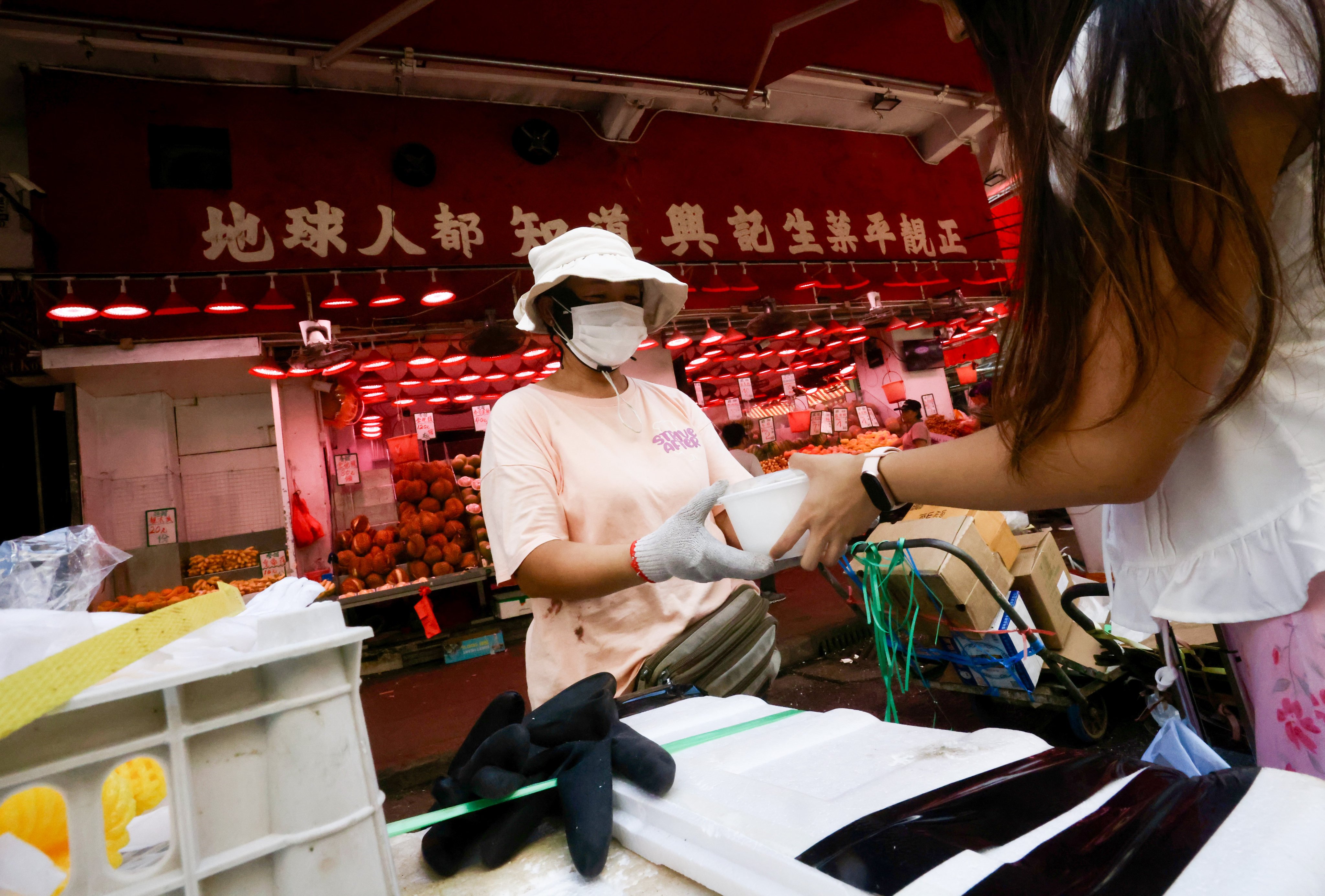 “Belle” hands a lunchbox to an elderly woman in Sham Shui Po. The Hong Kong student gives out free meals to underprivileged elderly people and in the city and documents it on Instagram. Photo: Jonathan Wong
