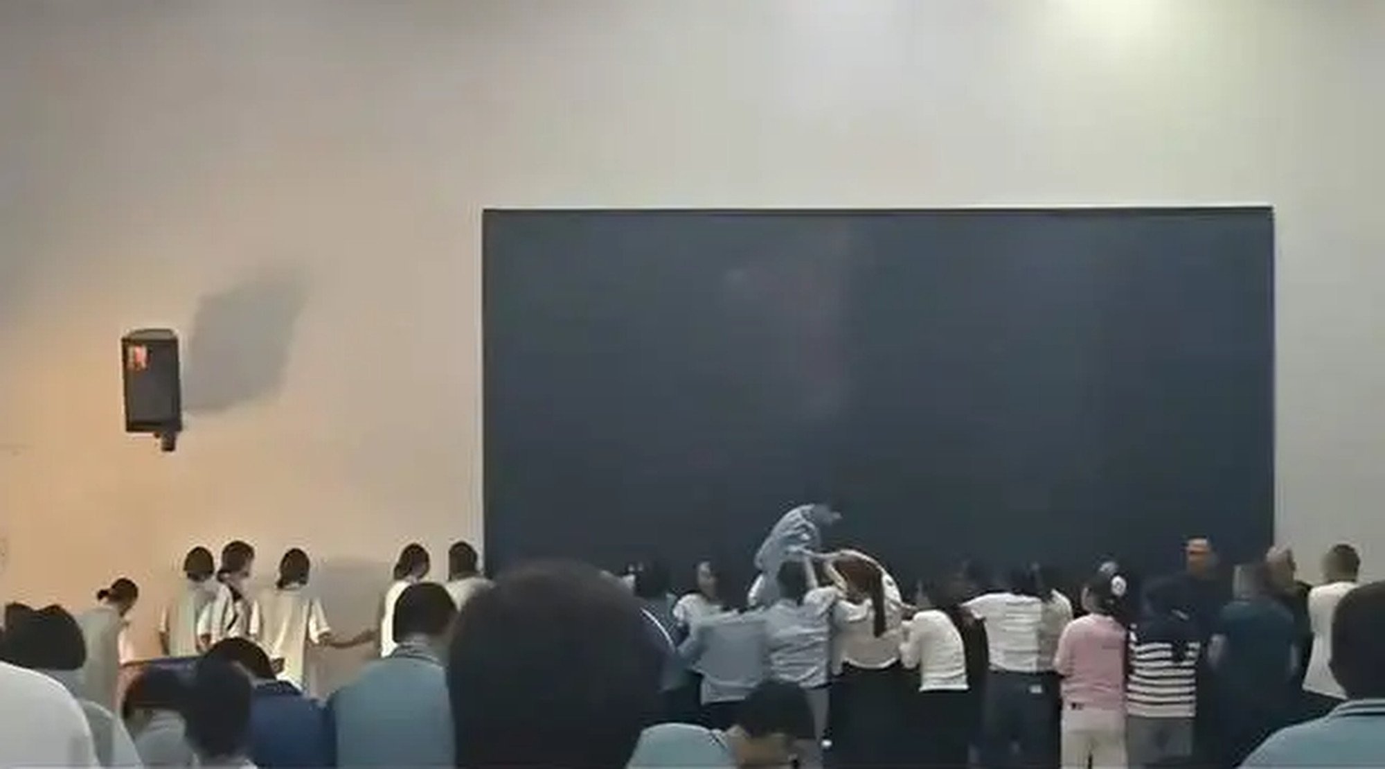 The shocking viral video shows students climbing over the backs of parents with the help of classmates. Photo: QQ.com