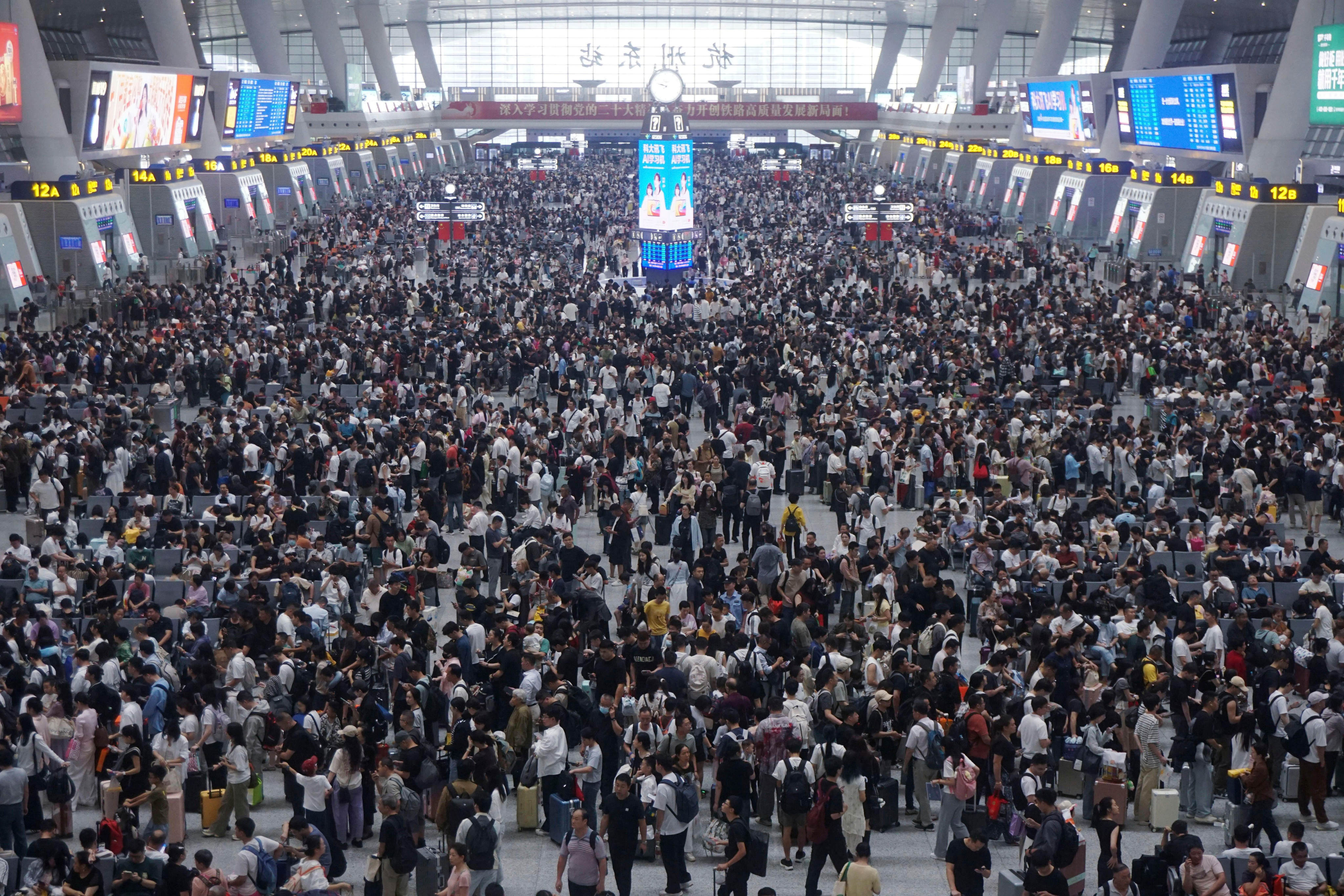 Travellers wait for trains at a railway station on Wednesday, the last day of the eight-day long national day holiday in Hangzhou in eastern China’s Zhejiang province. Photo: Chinatopix via AP
