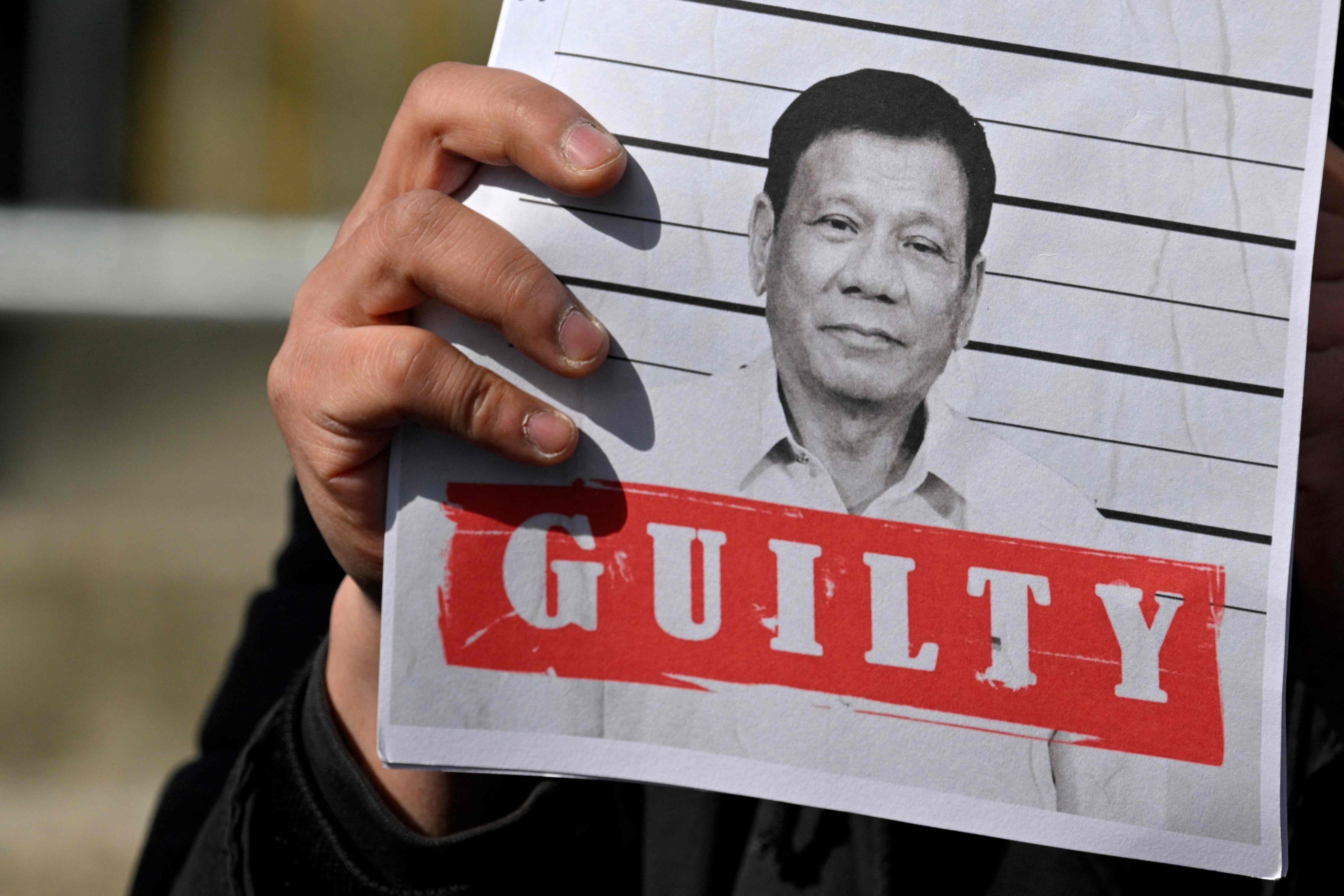 A protester holds a poster portraying former Philippine president Rodrigo Duterte at a rally in support of his detention outside the International Criminal Court in The Hague on March 14. Photo: AFP
