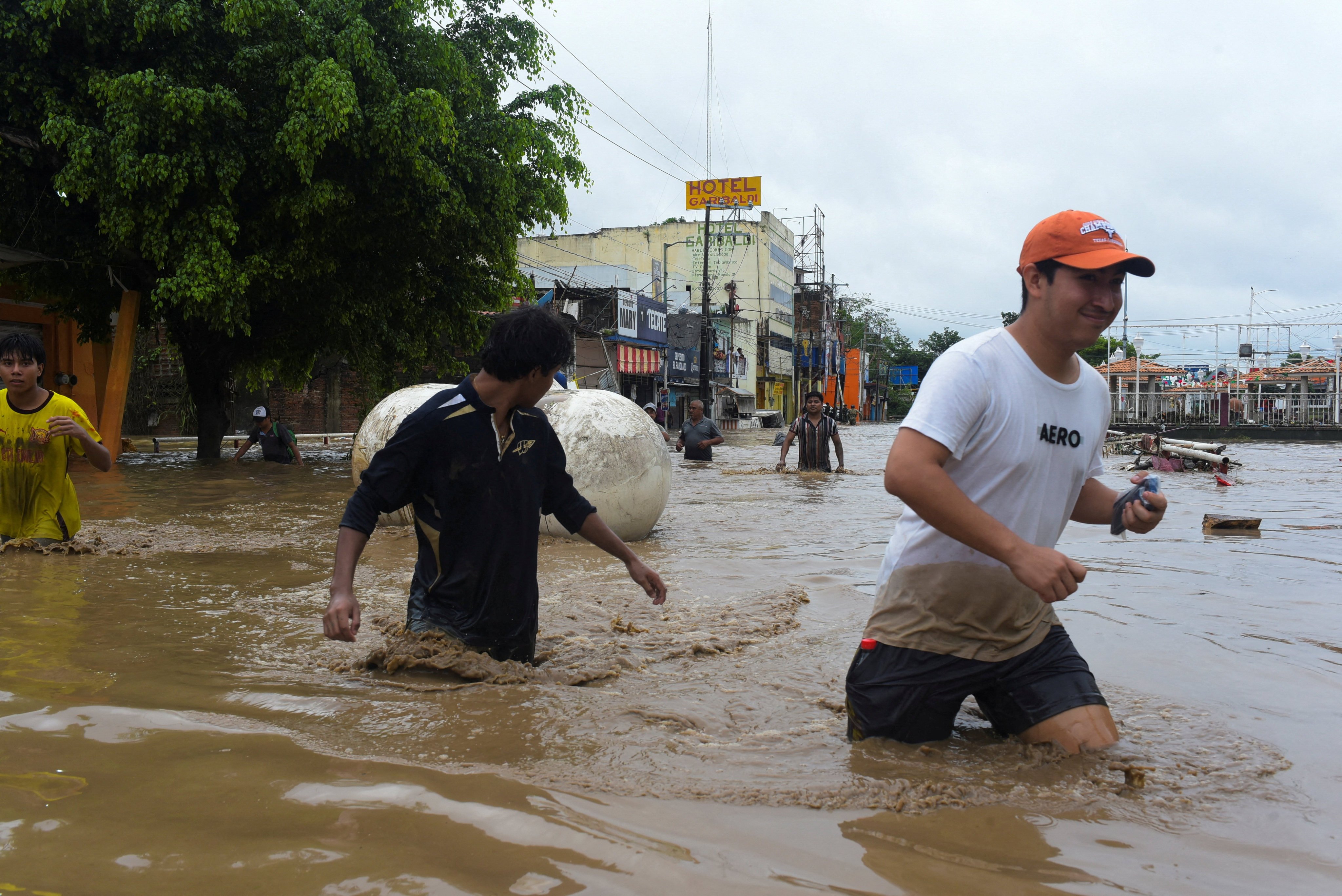 People wade through a flooded street in Poza Rica, Veracruz state, Mexico, on Friday. Photo: Reuters
