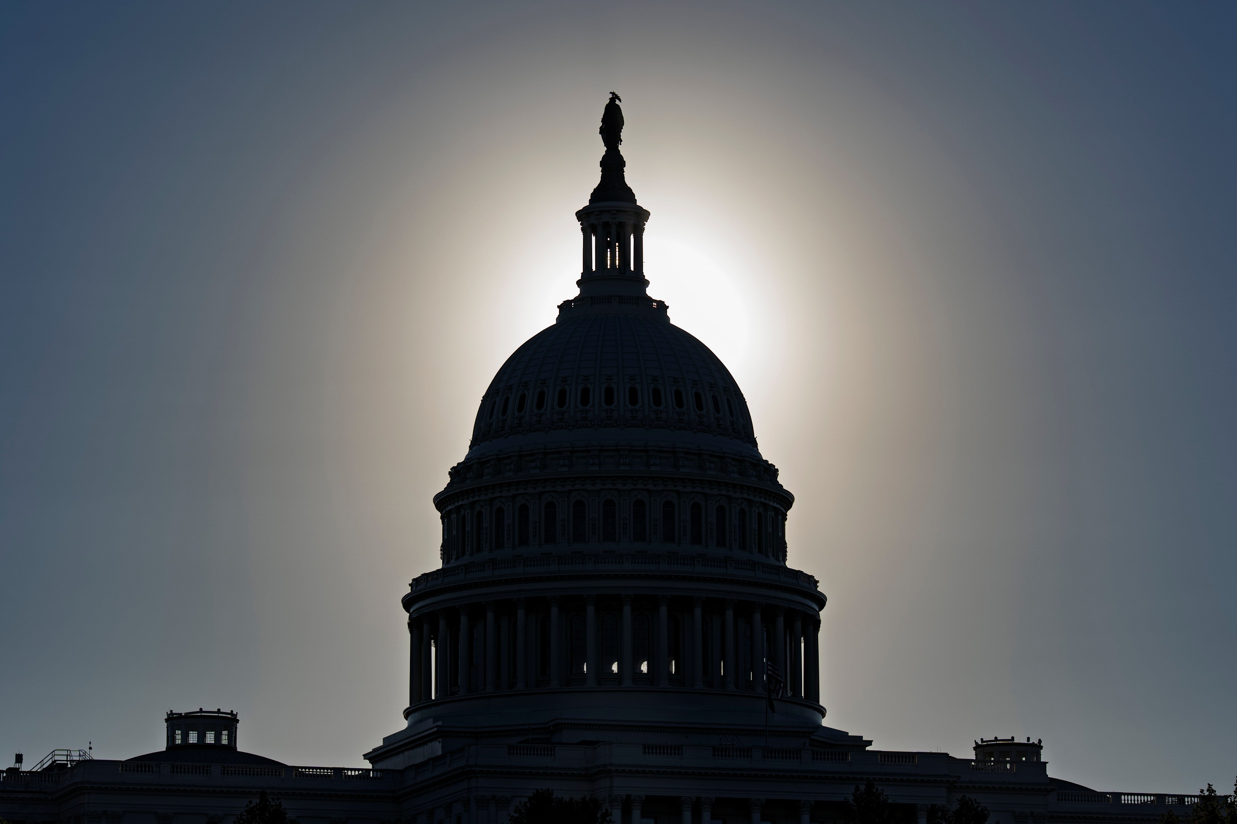 The US Capitol is silhouetted by the glare of the morning sun as a government shutdown begins its 10th day on Friday. Photo: AP