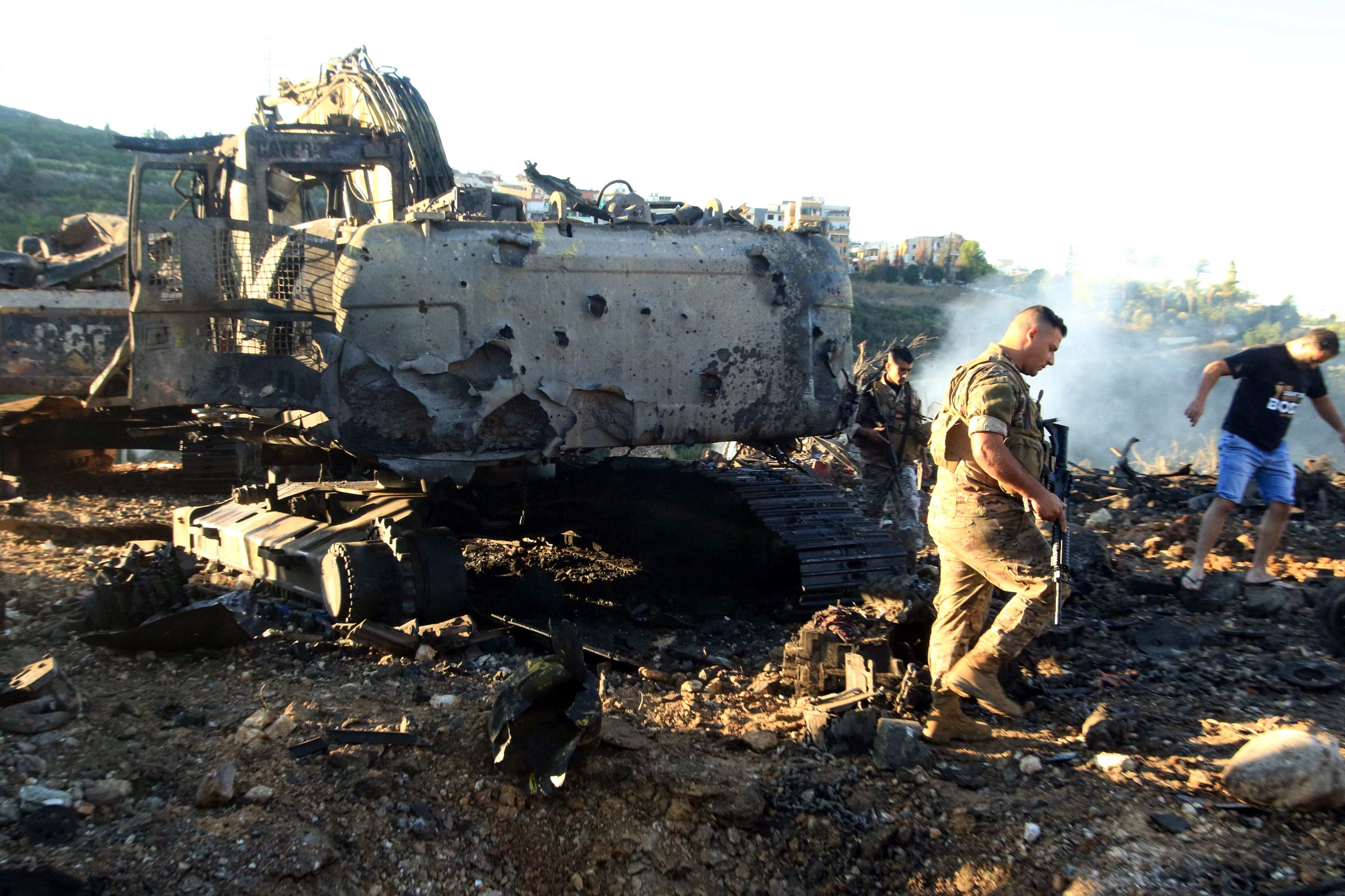 Lebanese soldiers walk next to a destroyed digger following an overnight Israeli strike on Msayleh in southern Lebanon on Sunday. Photo: AFP