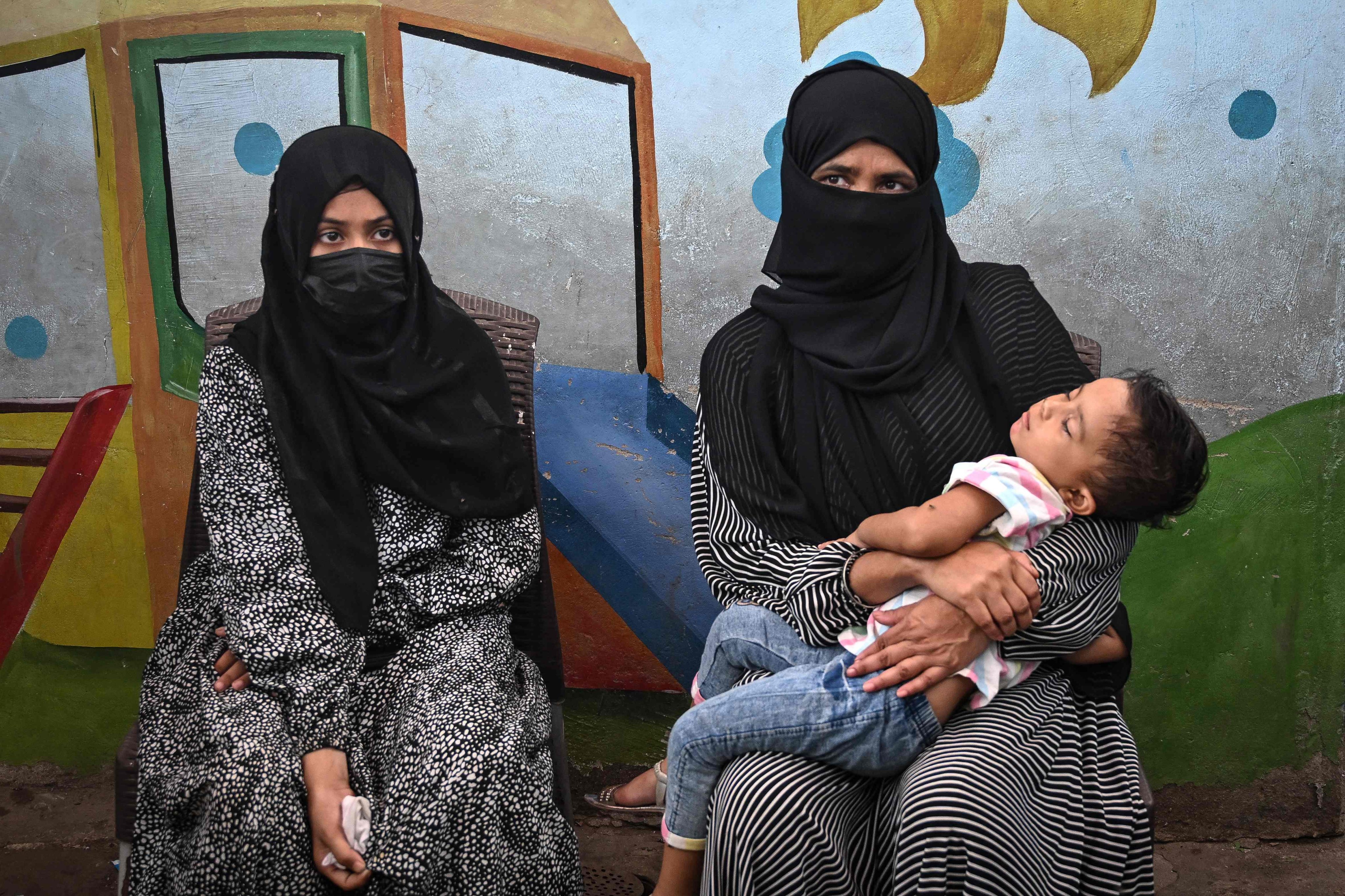 Amina (left), a household helper, sits beside her mother  during an interview in Karachi. Photo: AFP