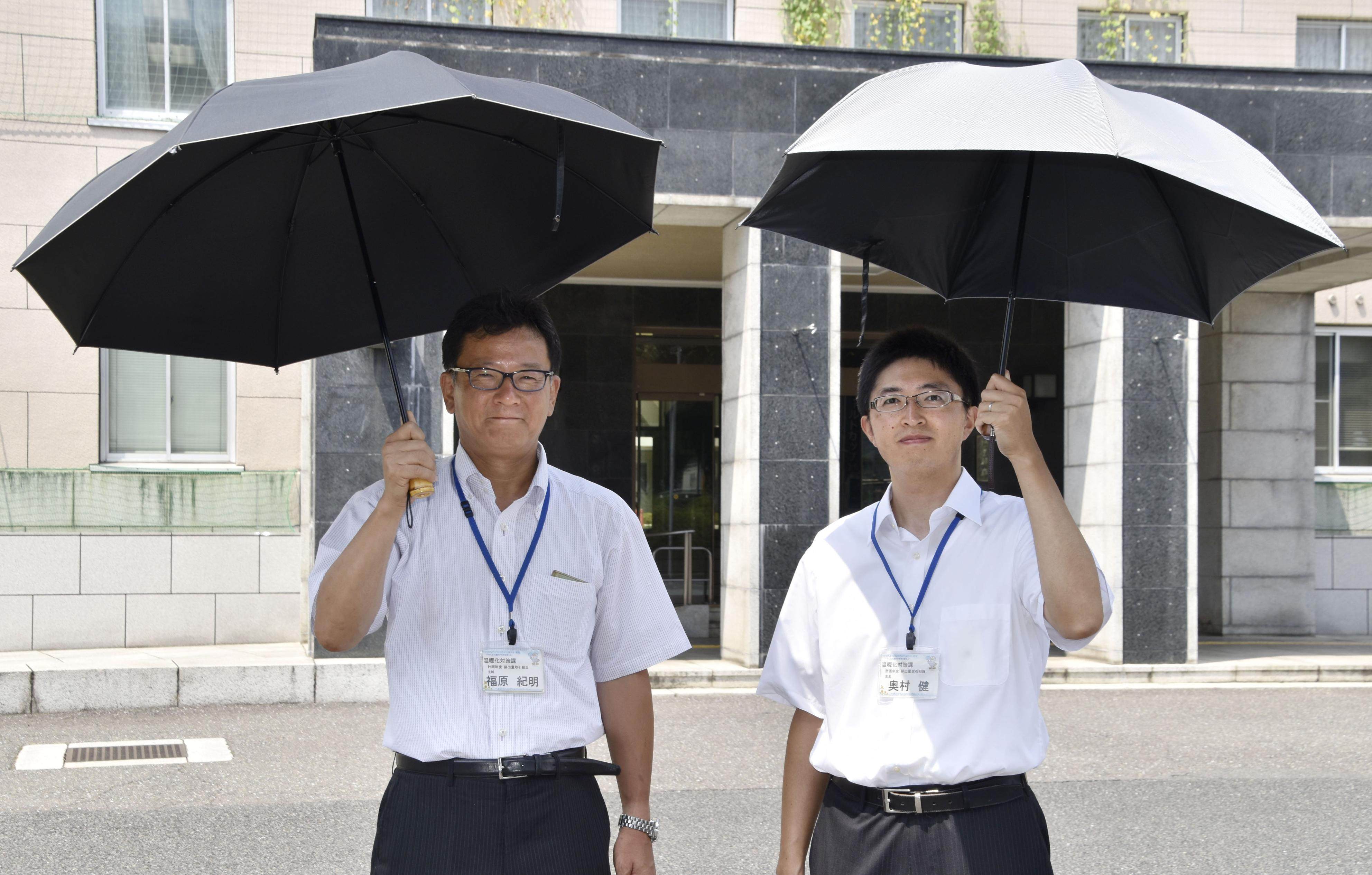 Saitama prefectural government officials promote parasols for men in Japan. Photo: Kyodo