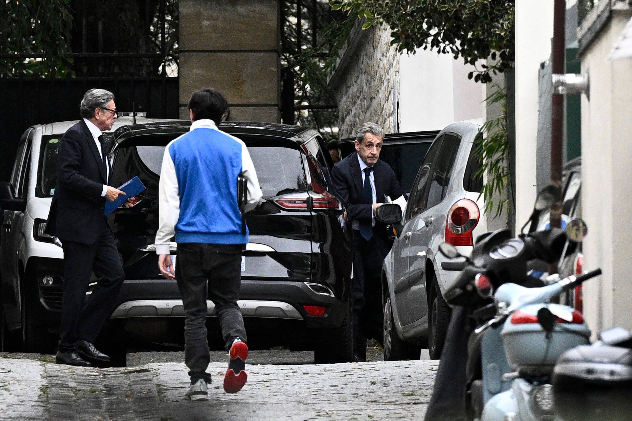 Nicolas Sarkozy exits a vehicle as he returns to his home in Paris following his meeting with prosecutors to be informed of the start of his jail sentence. Photo: AFP