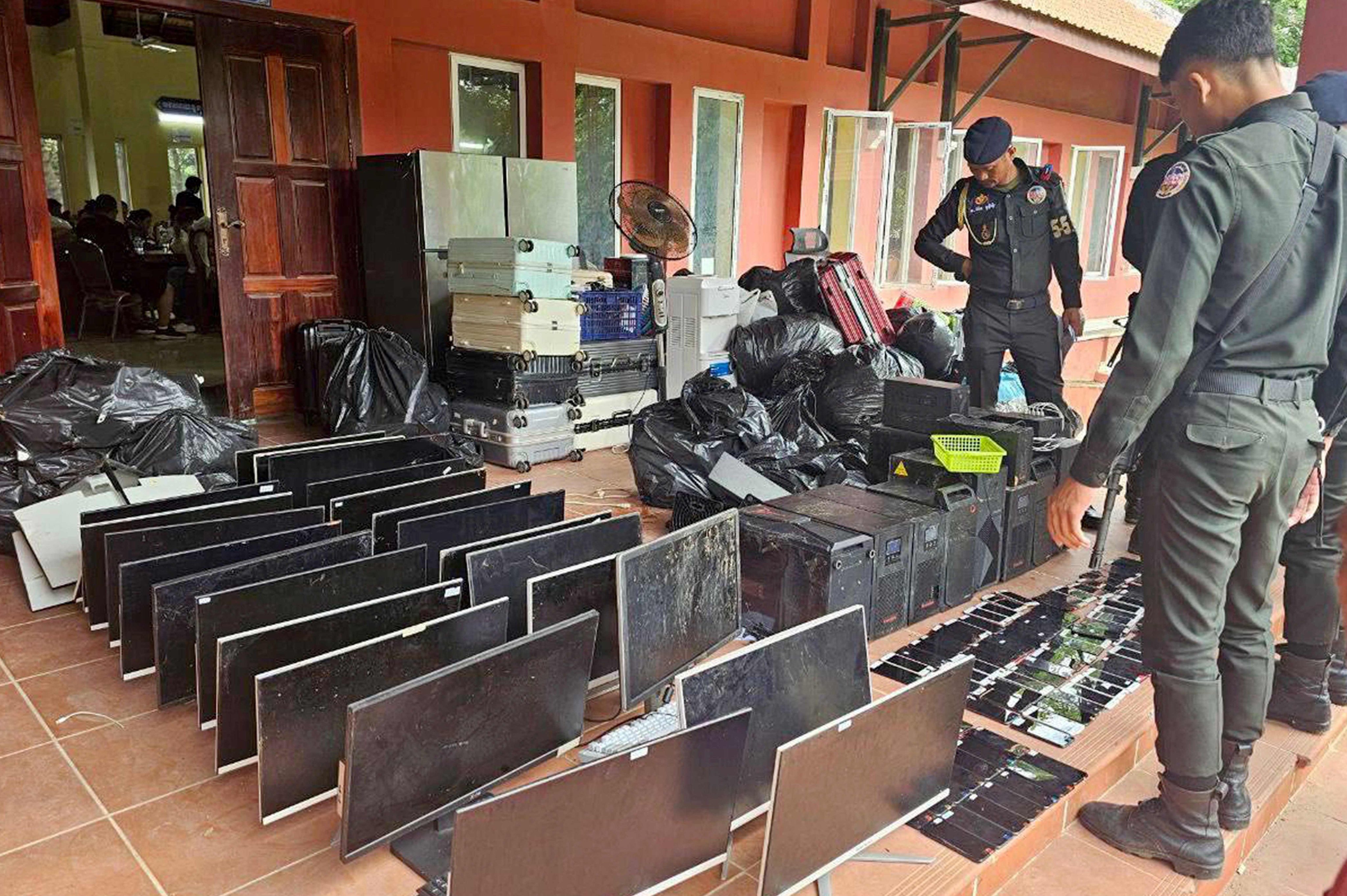 Cambodian military police look over equipment seized during a raid on a scam centre in Kandal province on July 17. Photo: Agence Kampuchea Presse/AFP