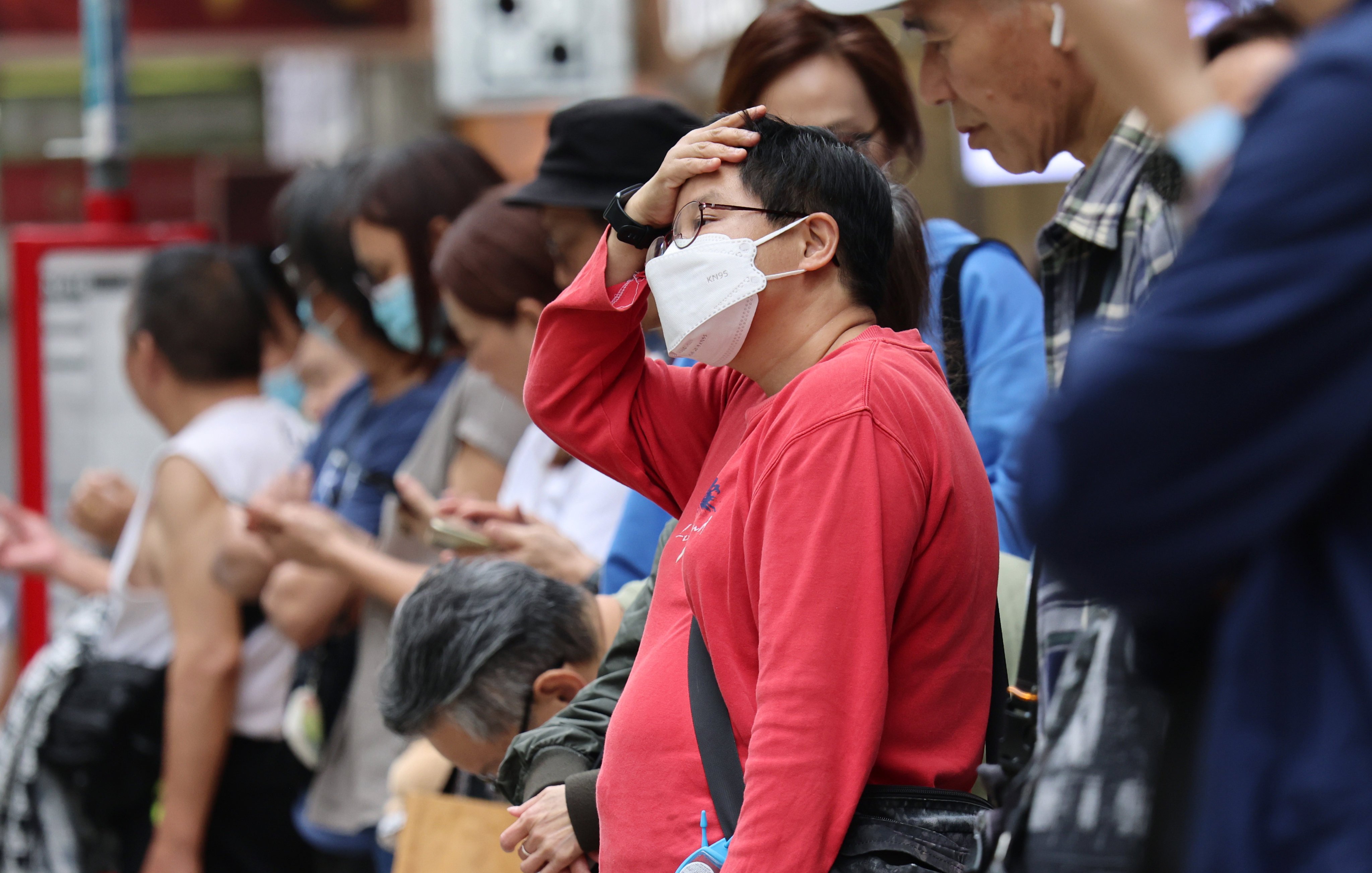 A woman wears a surgical mask at a bus stop in Mong Kok. Photo: Jelly Tse