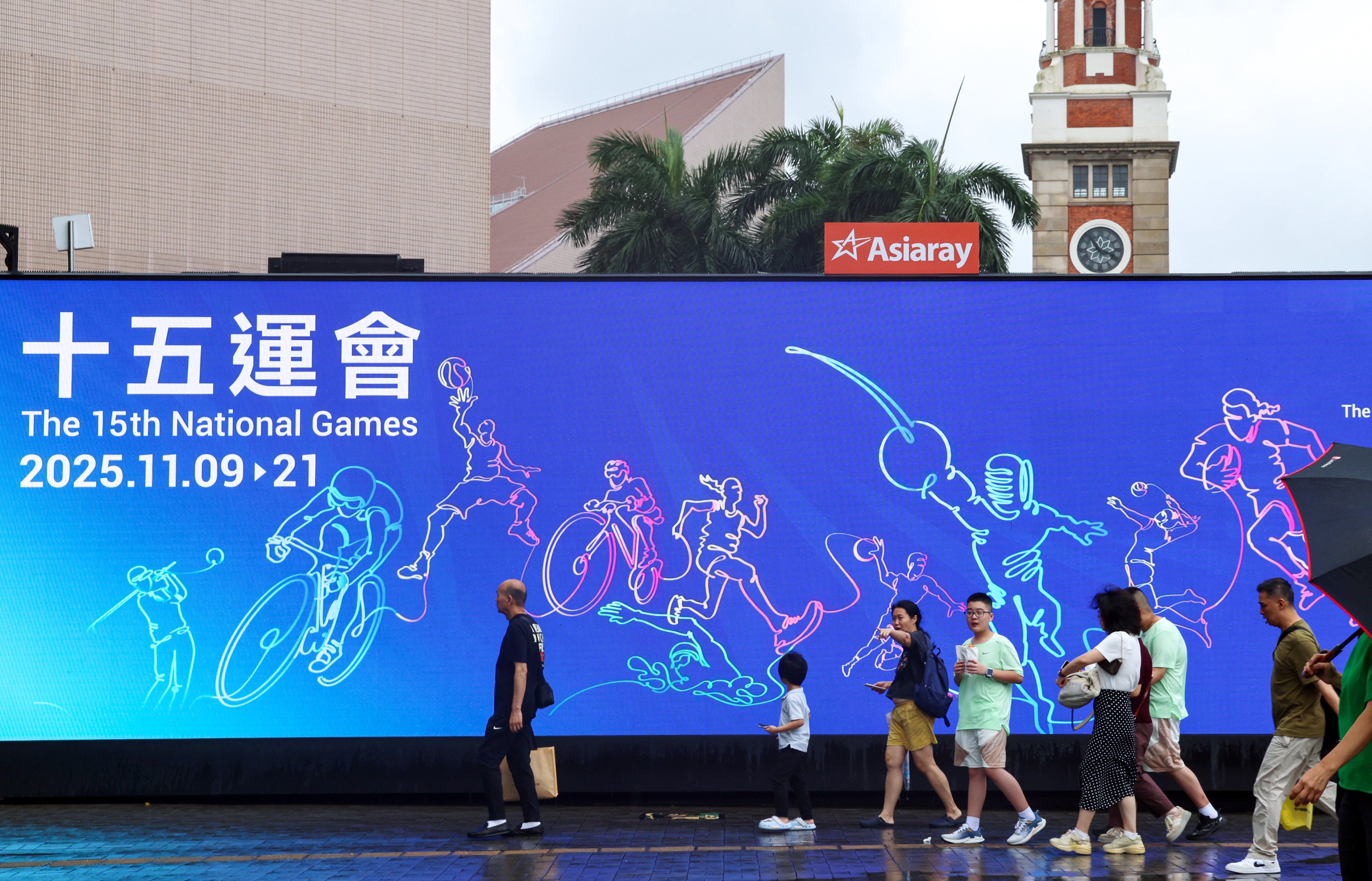 Pedestrians walk past an advertisement for the 15th National Games taking place in Guangdong province, Hong Kong and Macau. Photo: Jelly Tse