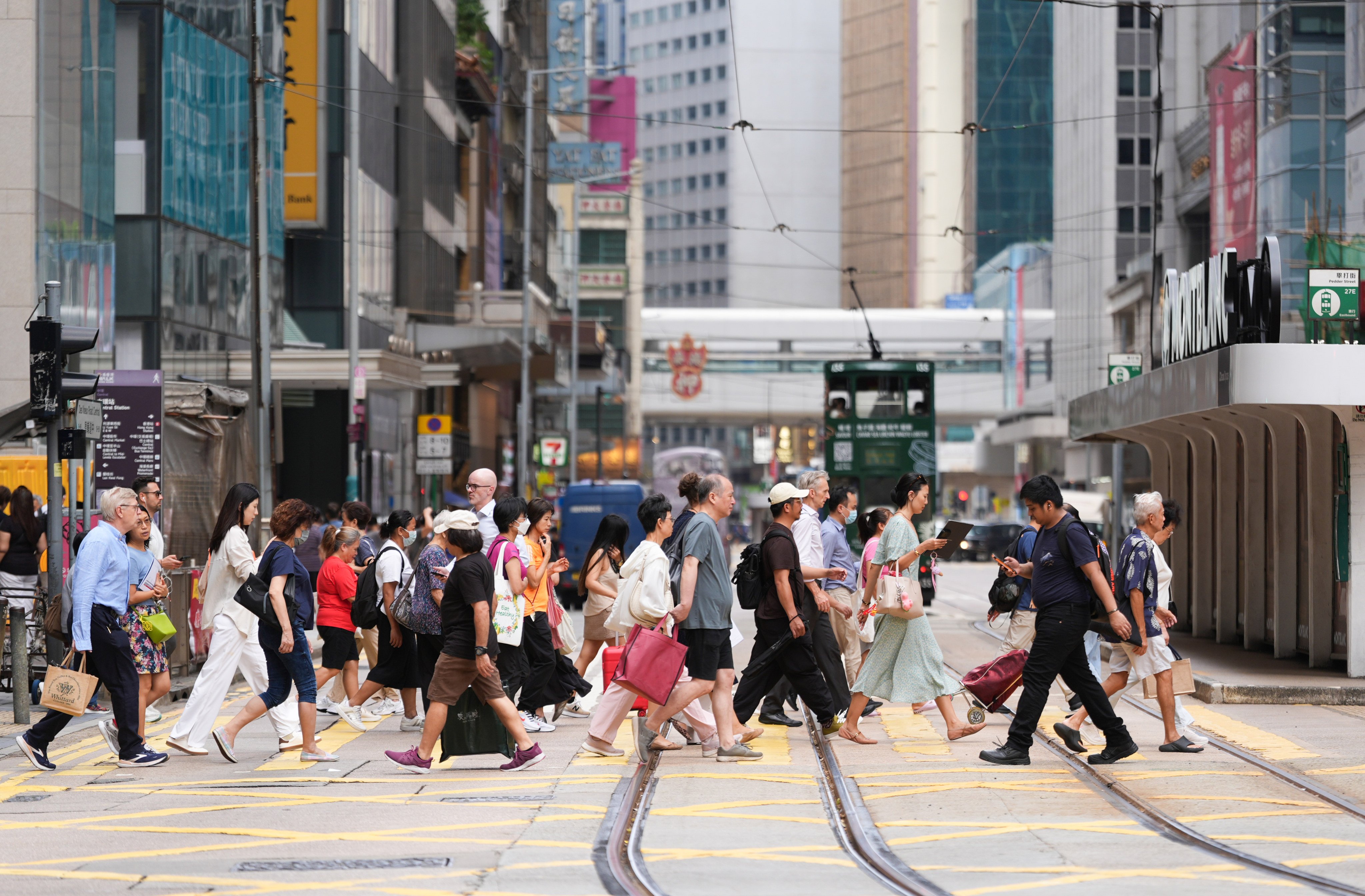 People cross a street in Central on September 16, 2025. Photo: Eugene Lee