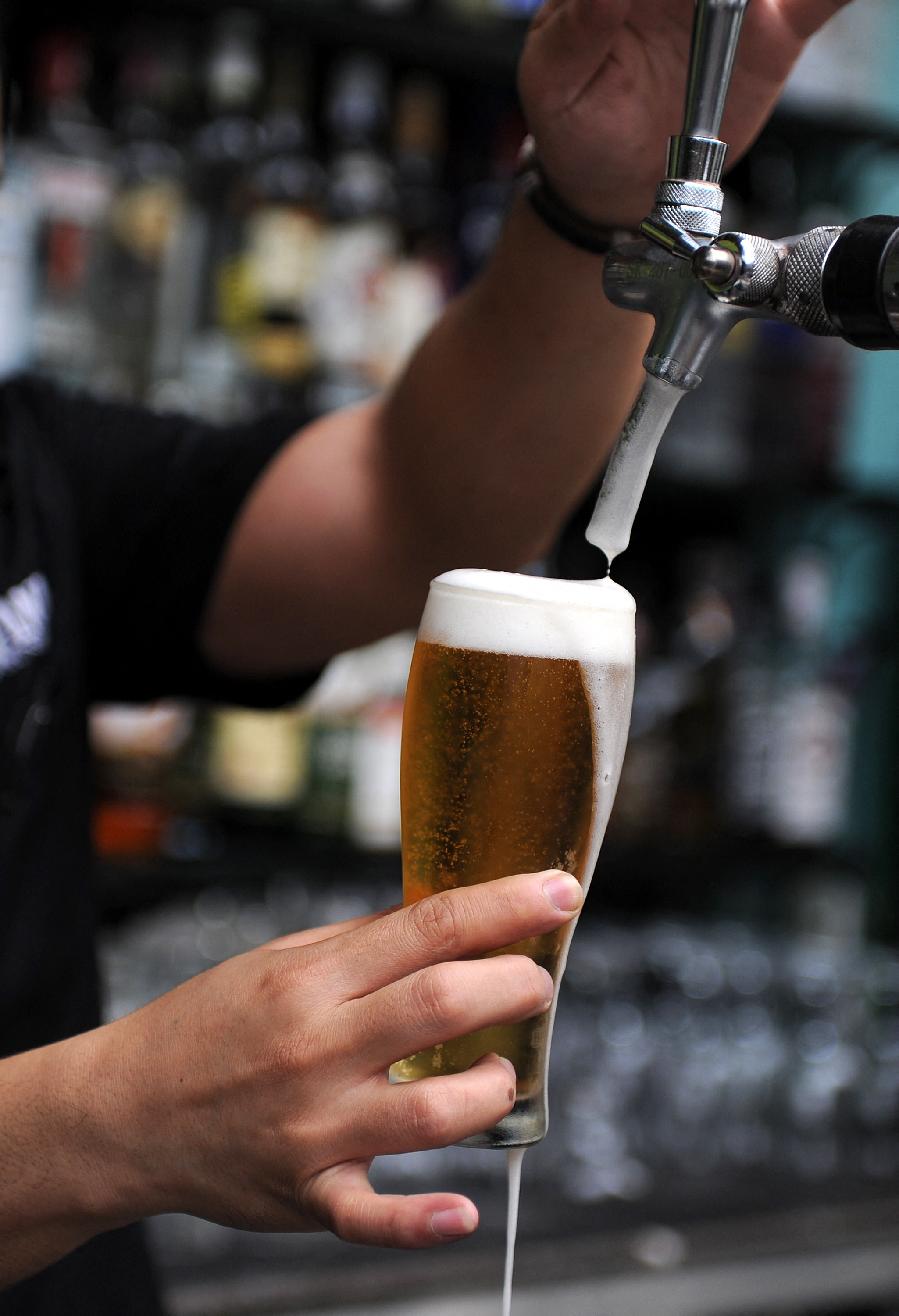 A bartender fills a glass with beer for a customer in Kuala Lumpur’s Bukit Bintang nightlife district. Photo: AFP