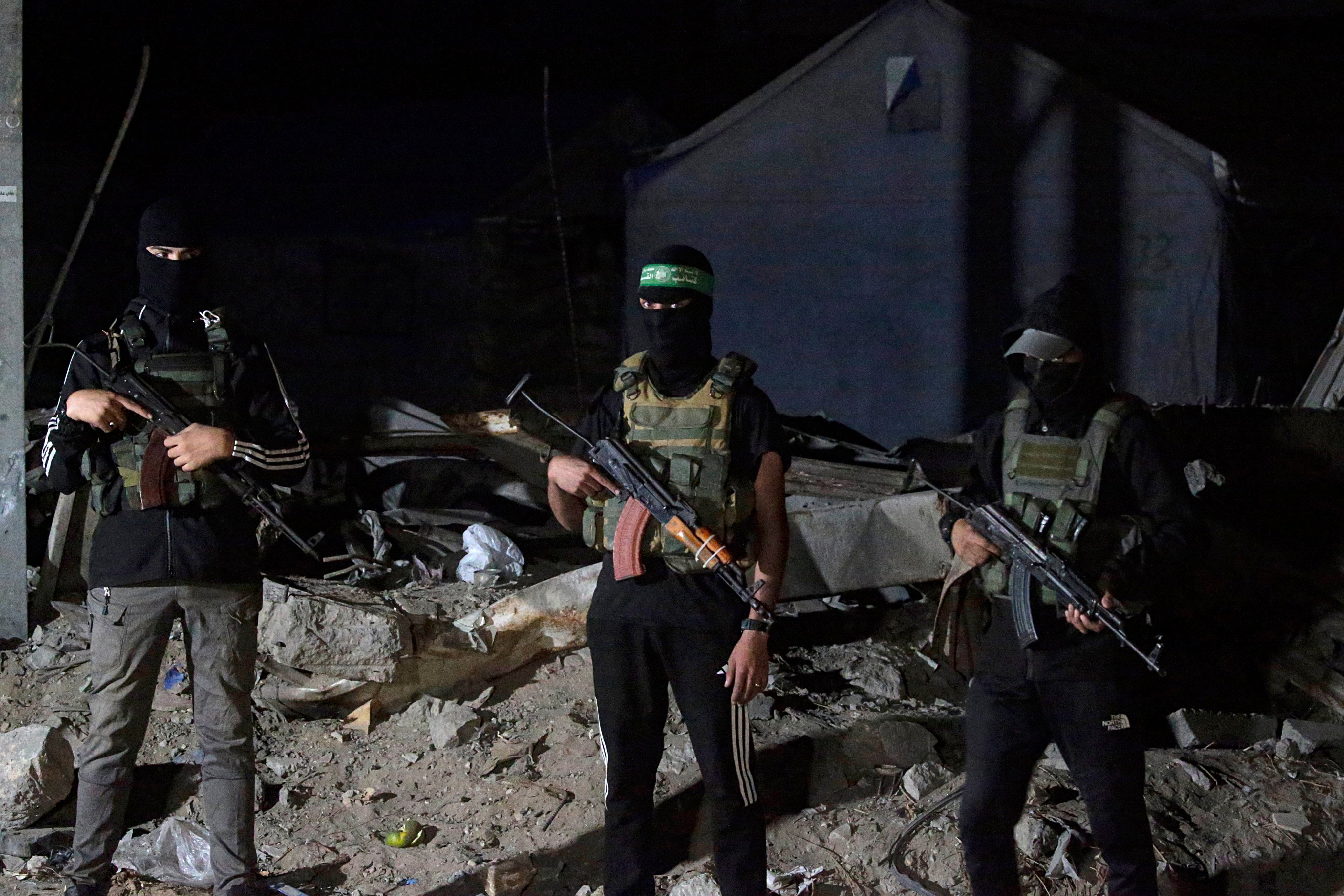 Hamas fighters stand guard as Red Cross vehicles arrive to transport remains of Israeli hostages on Wednesday. Photo: EPA