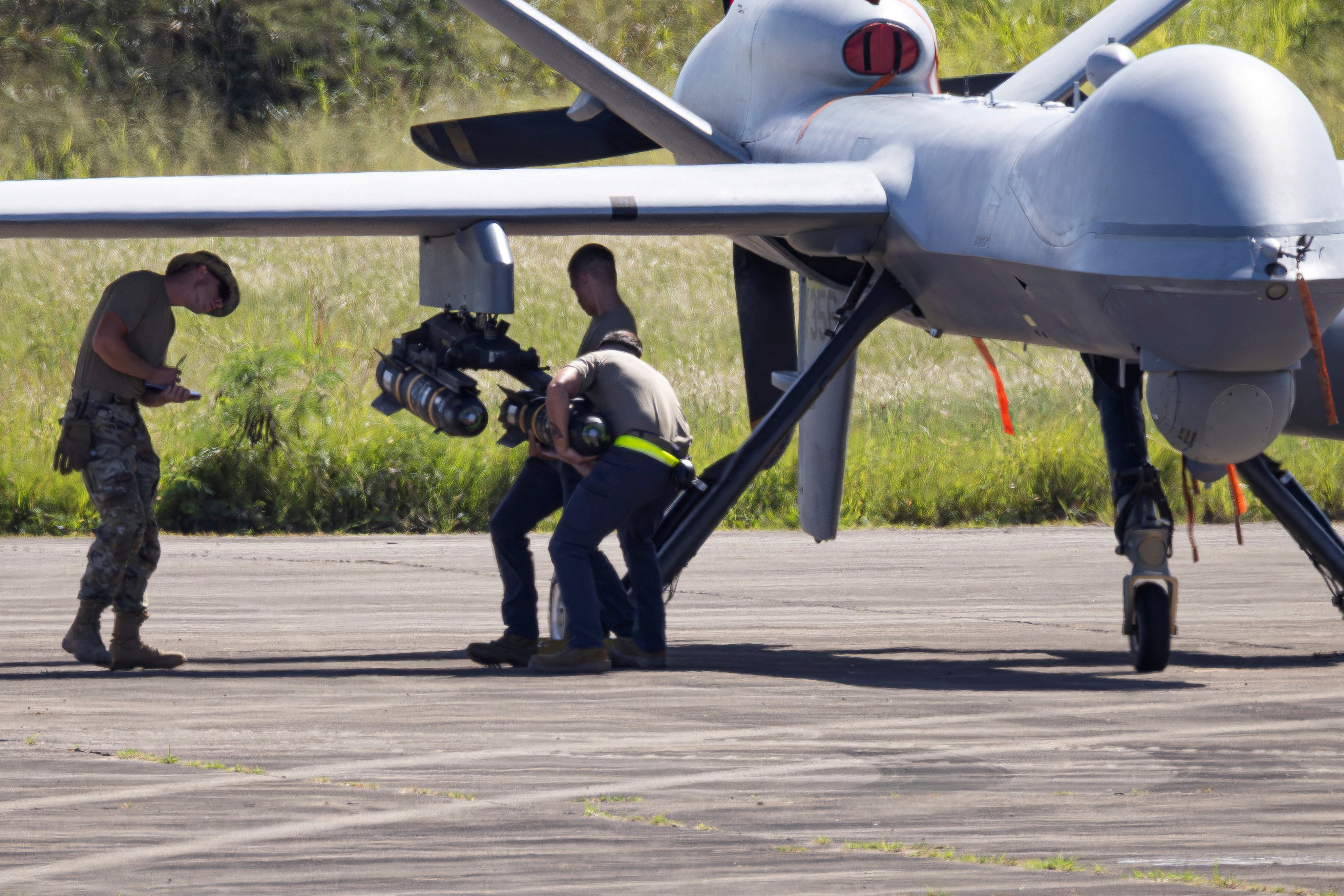 US Air Force personnel load missiles onto an MQ-9 Reaper drone on the tarmac at Rafael Hernandez Airport in Aguadilla, Puerto Rico. Photo: Reuters