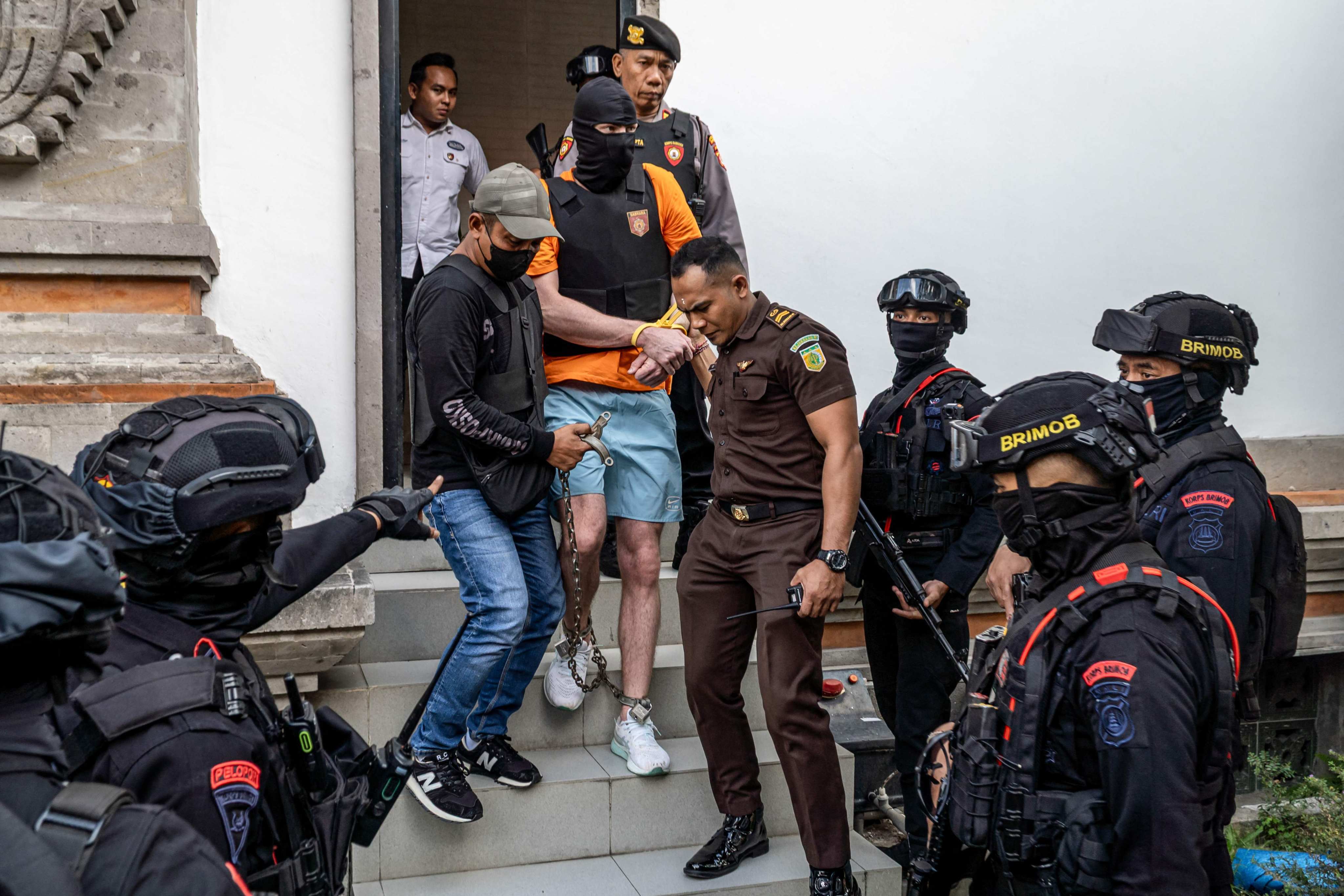 Australian suspect Darcy Francesco Jenson (centre), one of three men accused of murder over the shooting of Australian citizens, is escorted back to a prison after being questioned by prosecutors in Badung, Bali, Indonesia, on Wednesday. Photo: AFP