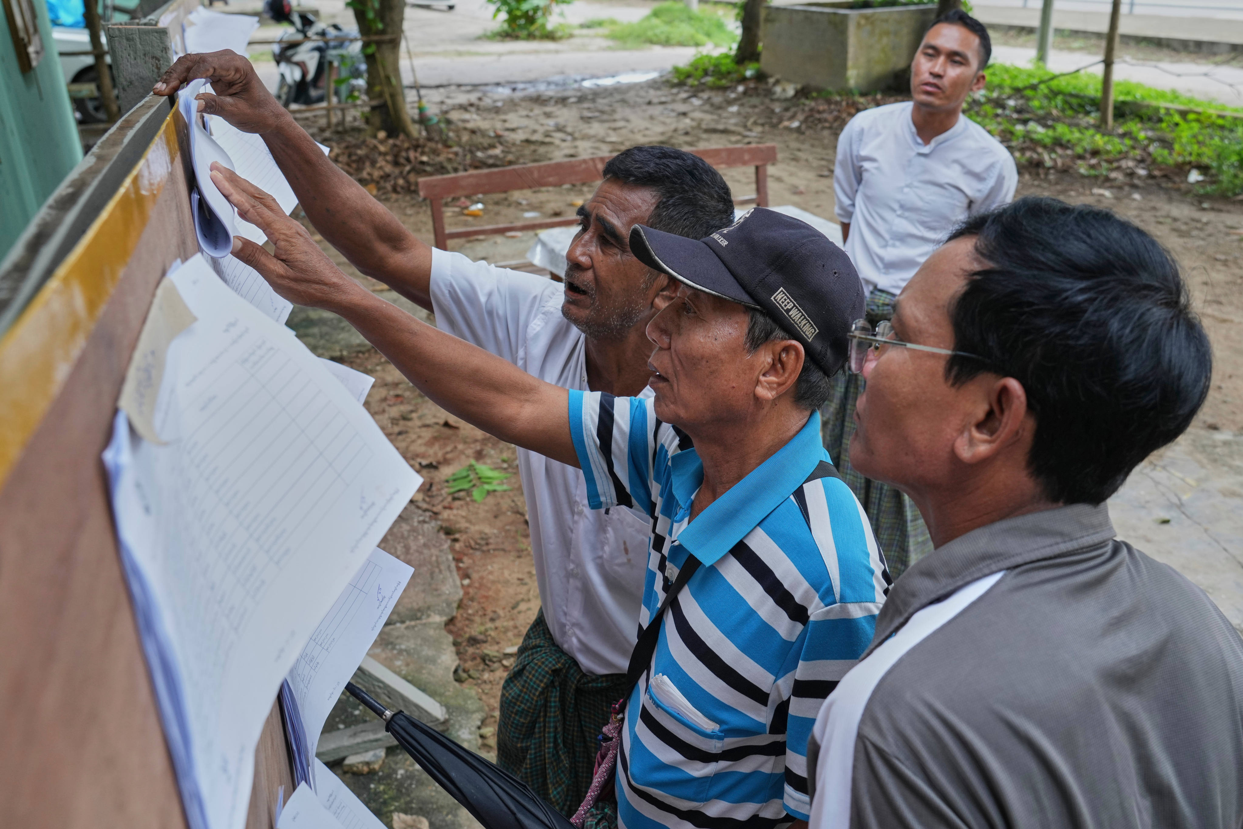 Men check for names on an officially published eligible-voter list at a ward administrative office in Naypyidaw, Myanmar, on September 30. Photo: AP