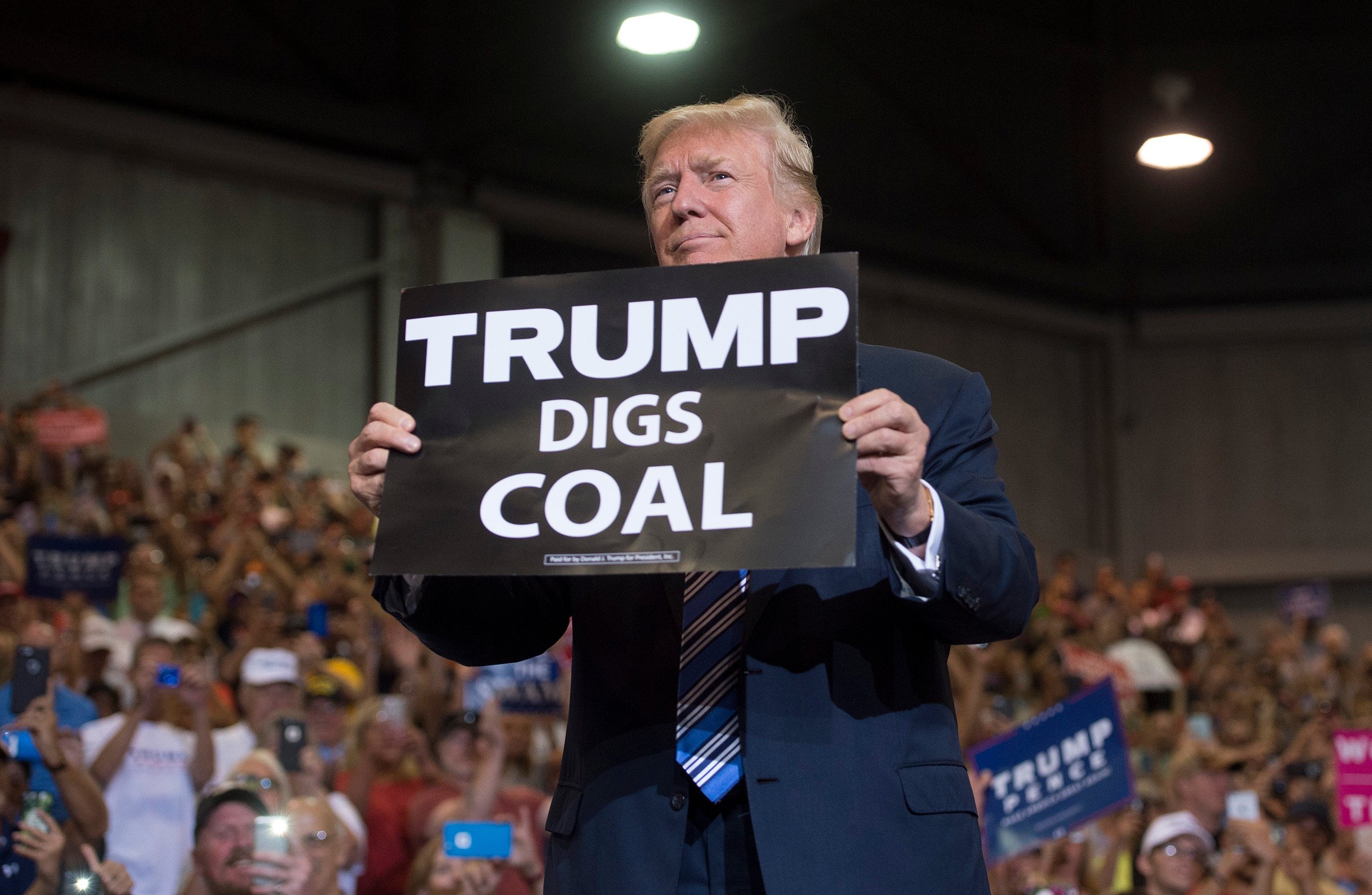 US President Donald Trump holds up a sign reading “Trump Digs Coal” in 2017, the year he first pulled out of the Paris Agreement on climate change. Photo: AFP/Getty Images/TNS