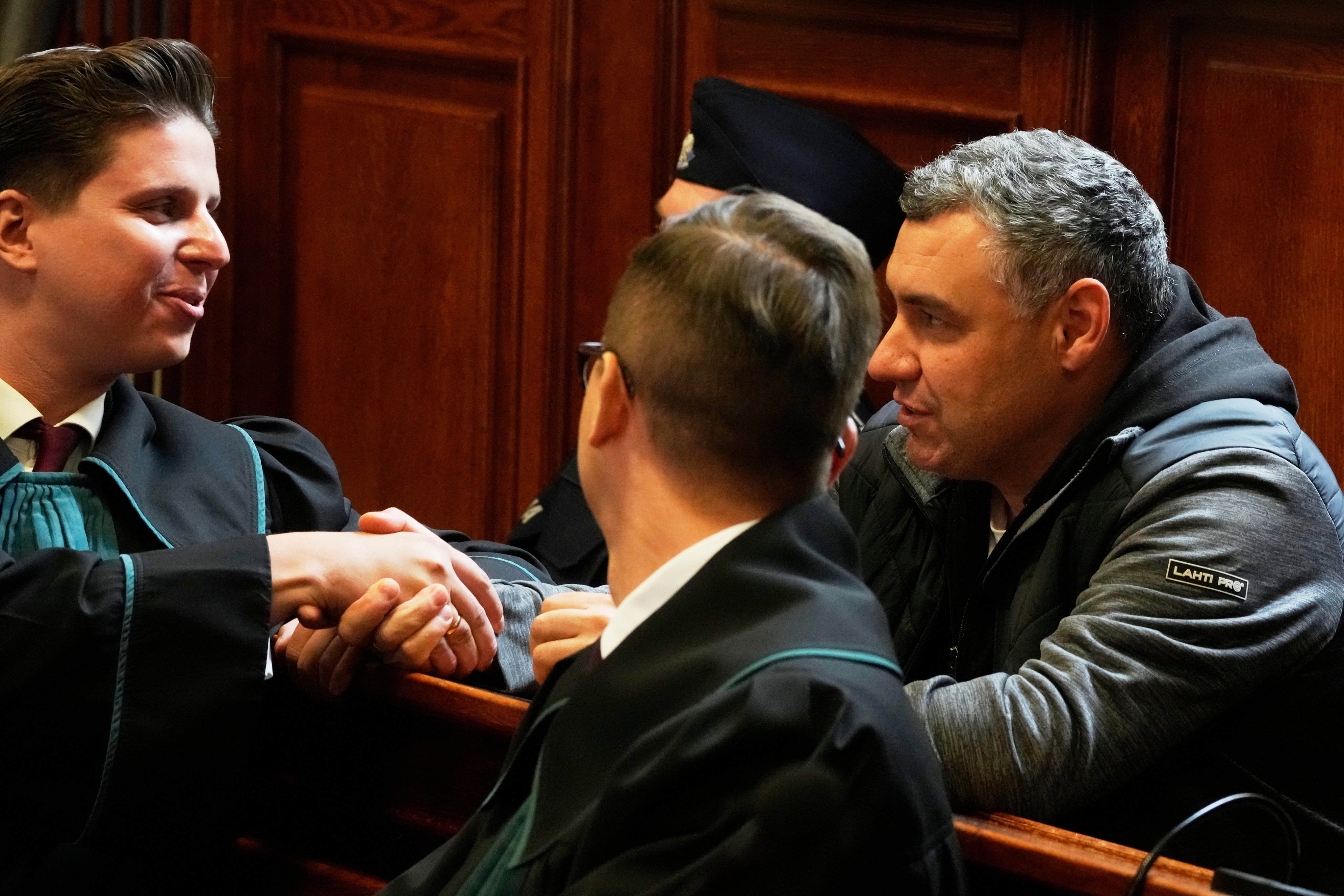 Ukrainian defendant Volodymyr Zhuravlov (right) shakes hands with his lawyer in Warsaw on Friday as a judge announces the decision not to allow for extradition to Germany. Photo: AP