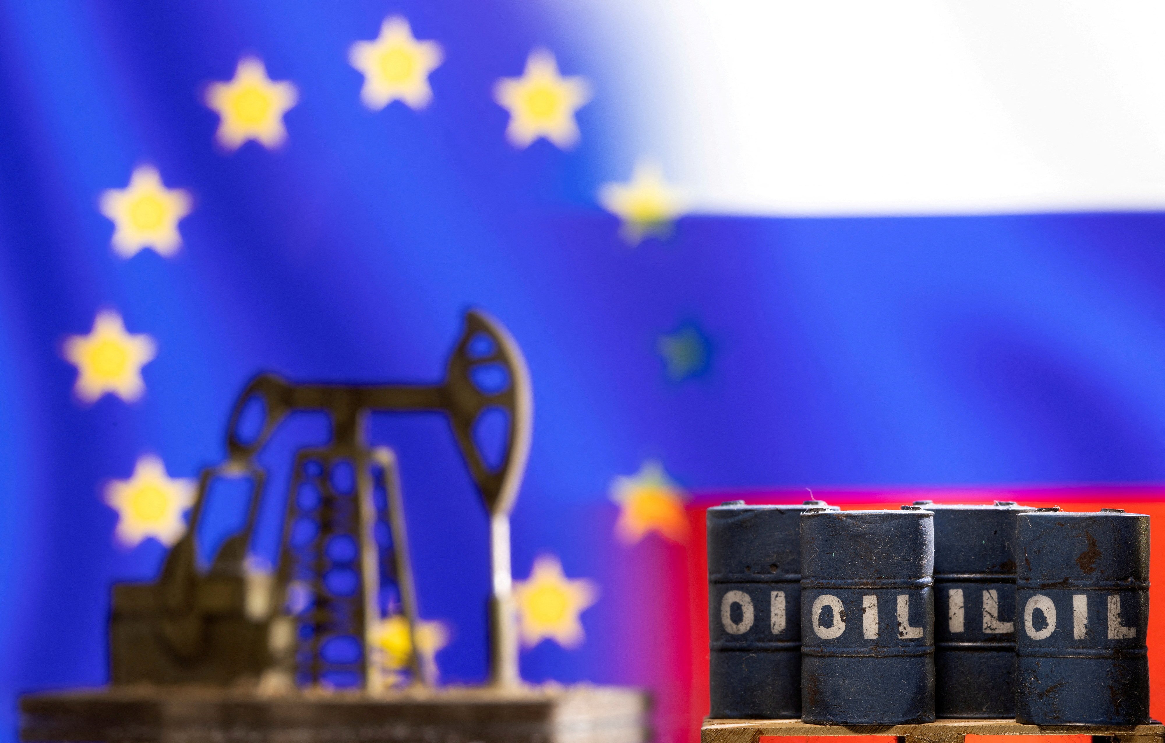 Oil barrels and a pump jack are seen in front of EU and Russia flag colours. Photo: Reuters