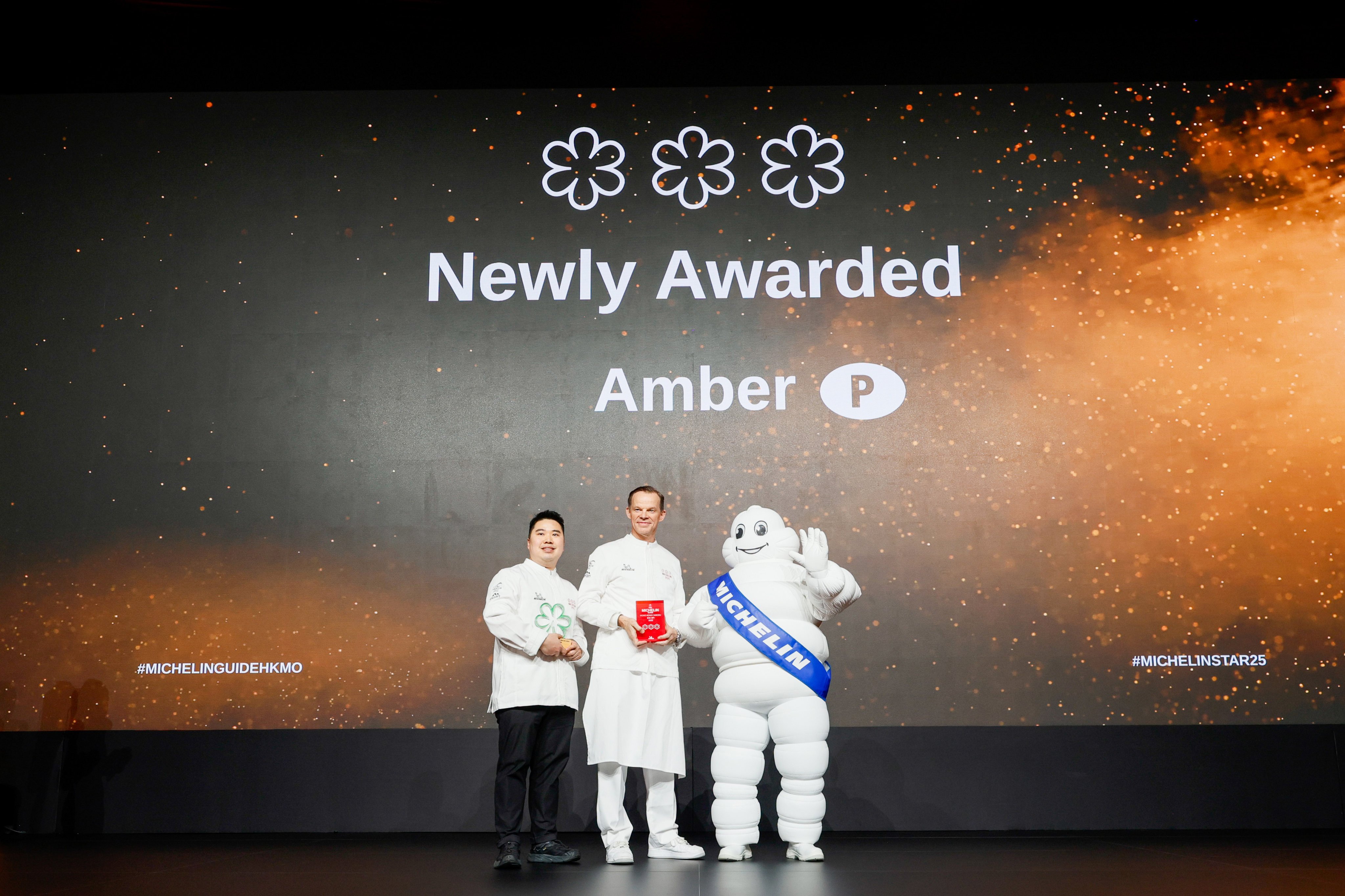 Amber culinary director Richard Ekkebus (centre) and chef de cuisine Terry Ho (left) receive the restaurant’s award for its third Michelin star at the Michelin Guide Hong Kong and Macau 2025 awards ceremony at the Grand Lisboa Palace Resort Macau on March 13, 2025.