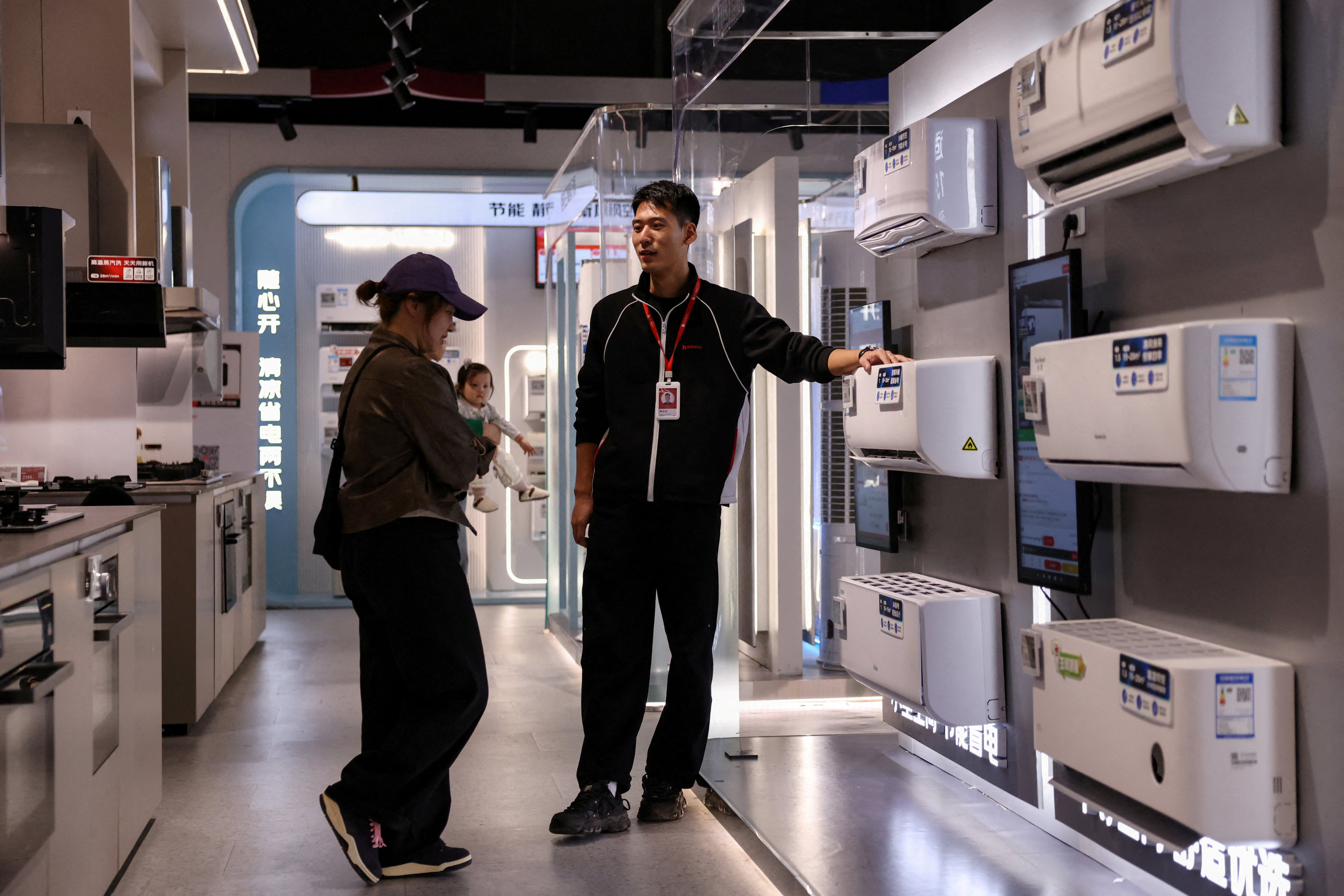 A staff member attends to a customer at a home appliance centre in Beijing on October 19. Diverting government resources to social spending would improve the confidence of Chinese people to spend more of their hard-earned income. Photo: Reuters