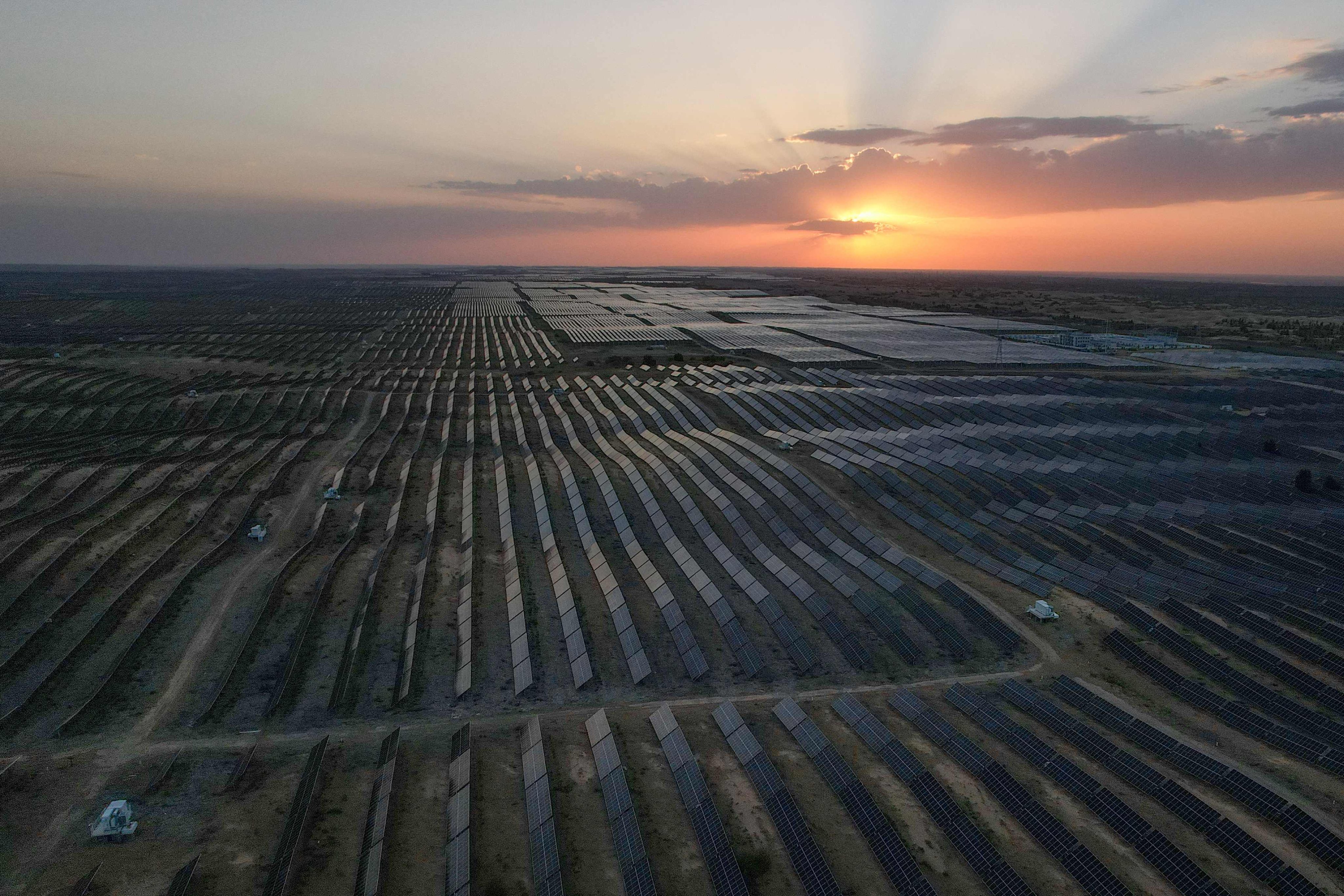 The sun sets over solar panels deployed at the Kubuqi Photovoltaic Desert Control Project near Ordos, Inner Mongolia autonomous region, on August 11. Photo: AFP
