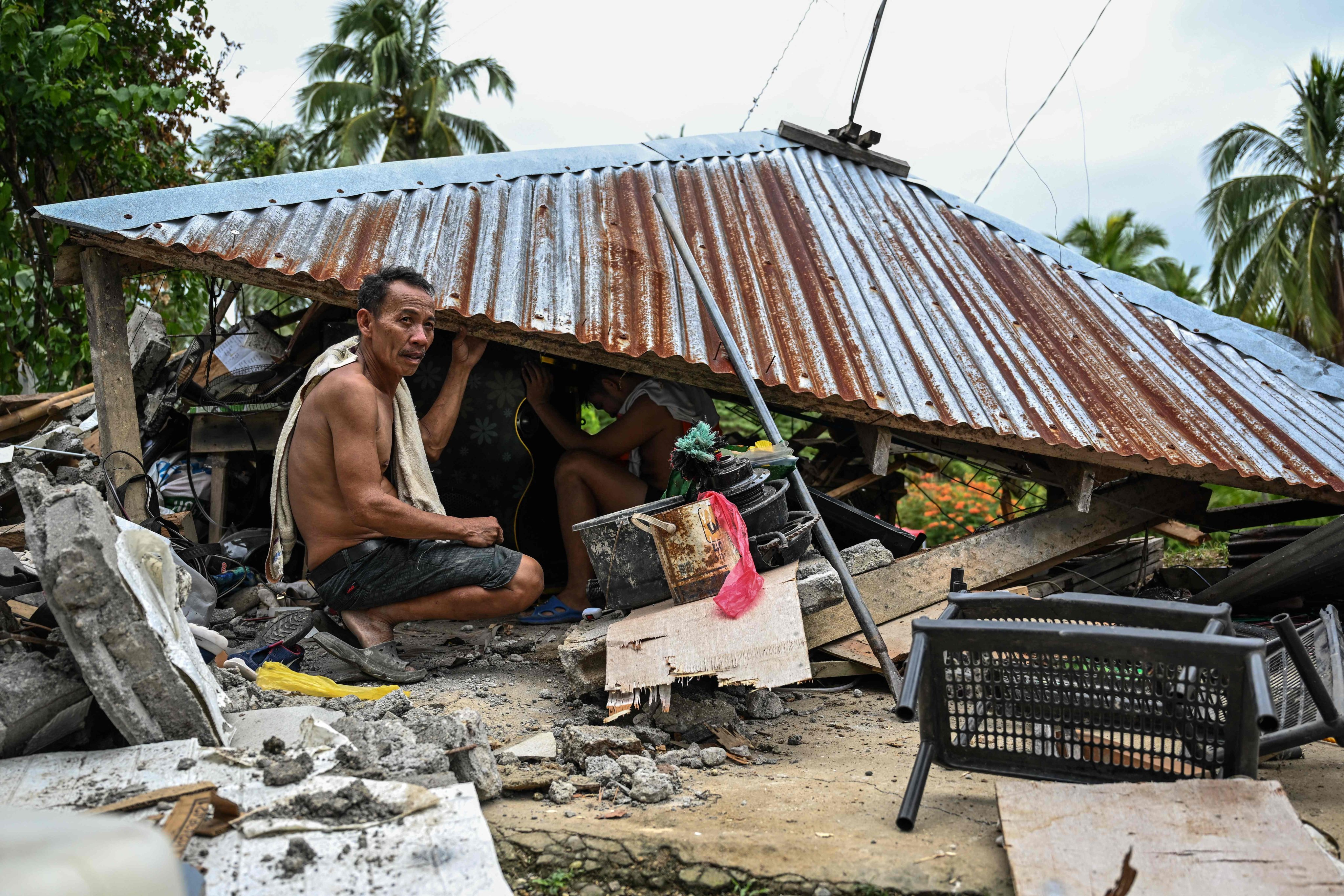 Locals look for items in a collapsed house in Manay, in the province of Davao Oriental on October 11, after two powerful quakes struck off the southern Philippines on October 10. Photo: AFP