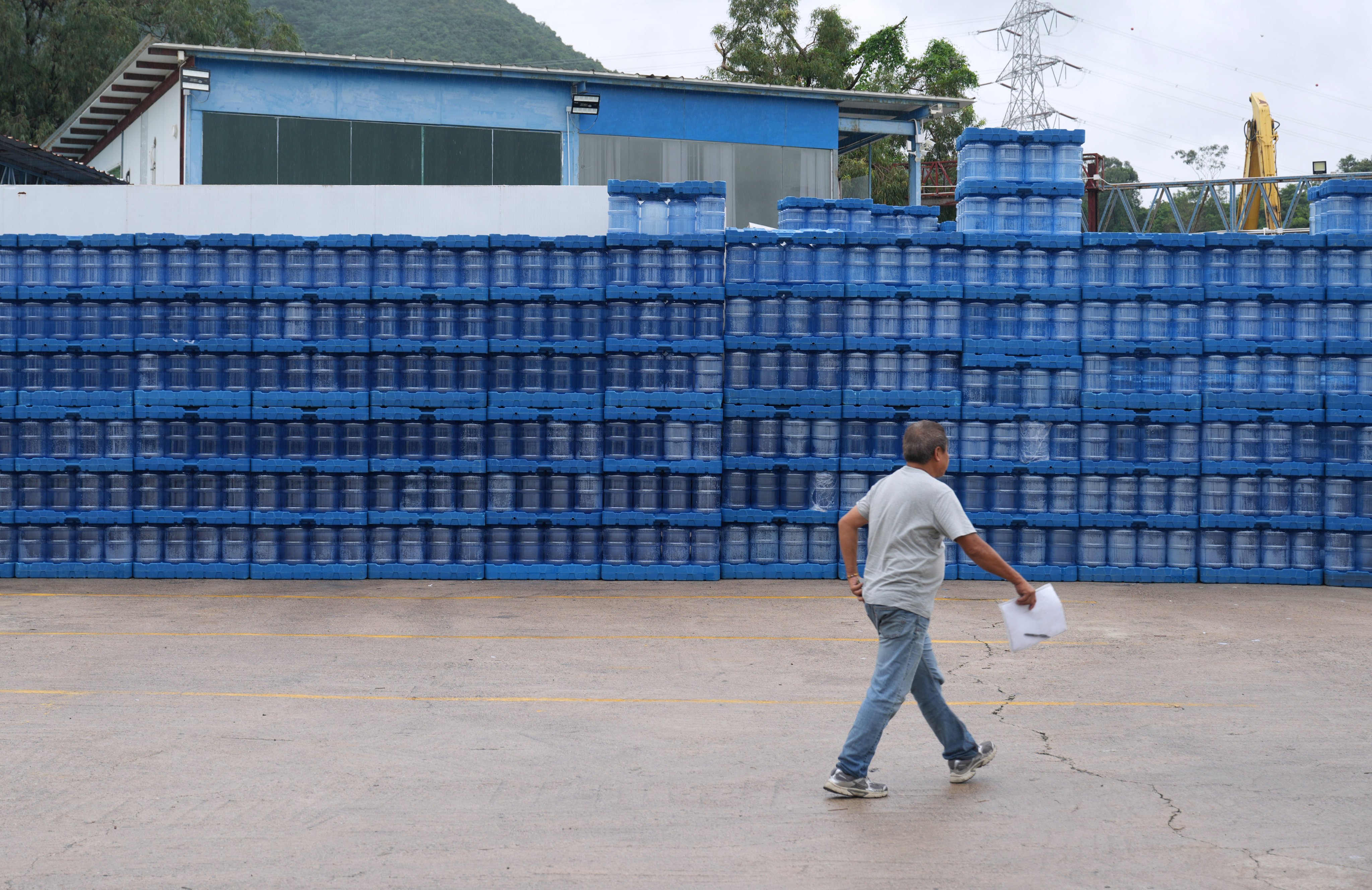 A person walks past empty distilled water bottles at a logistics company in Yuen Long, on August 19. Photo: Sam Tsang