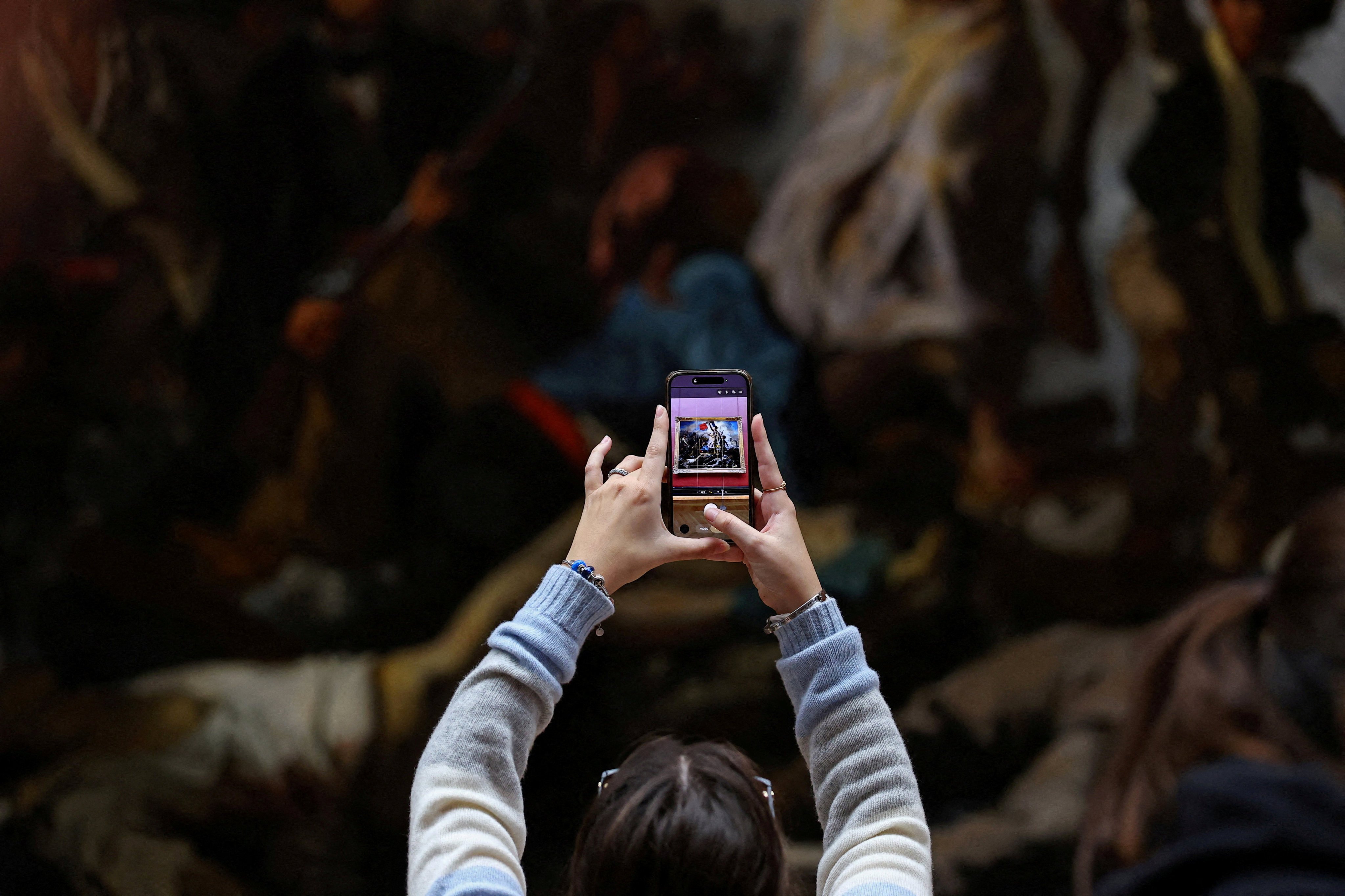 A visitor takes a picture of a painting at the Louvre on the day it reopened to the public for the first time since last Sunday’s heist. Photo: Reuters